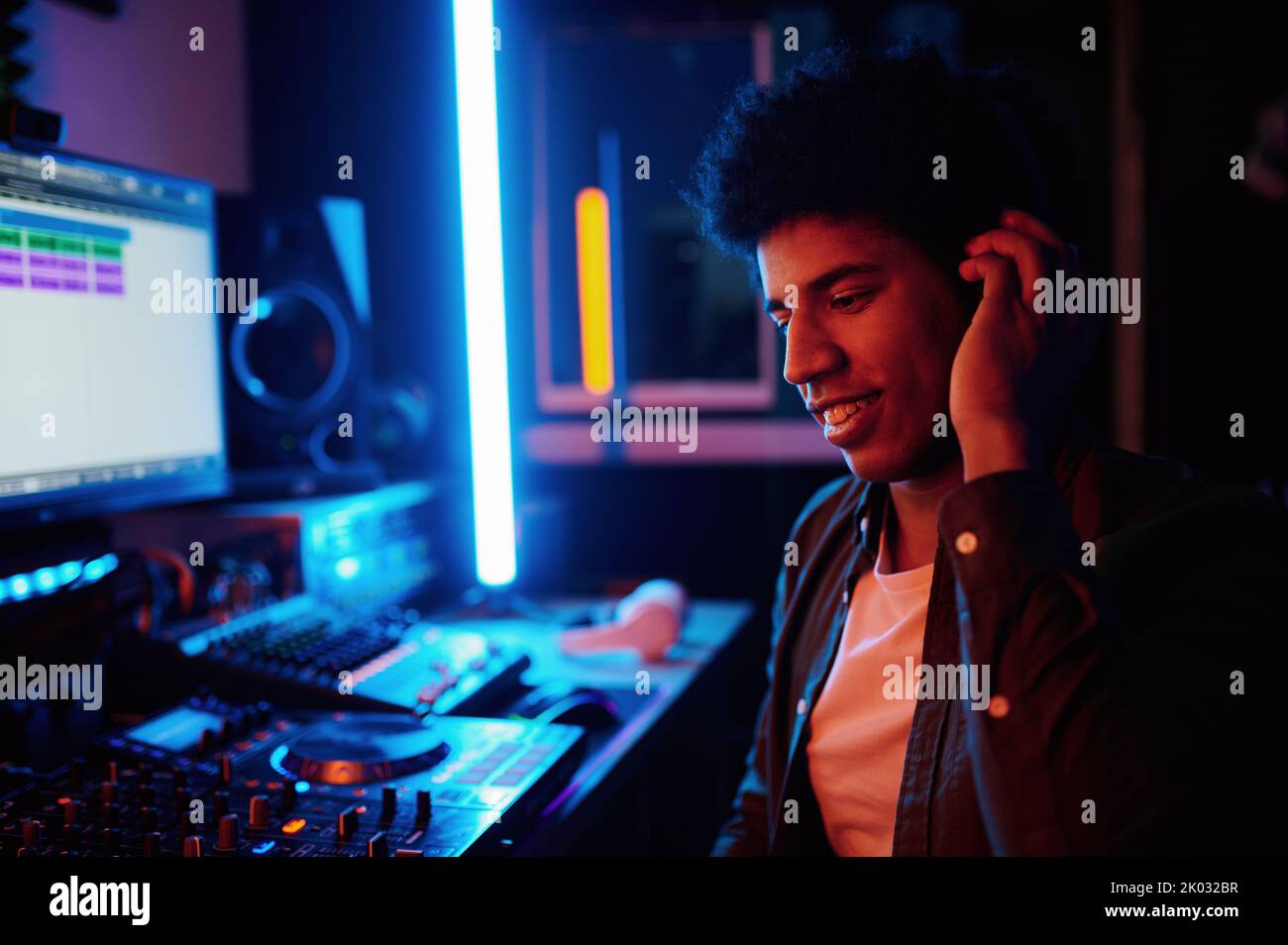 Felice produttore di musica che ascolta il nuovo brano in cuffie Foto Stock