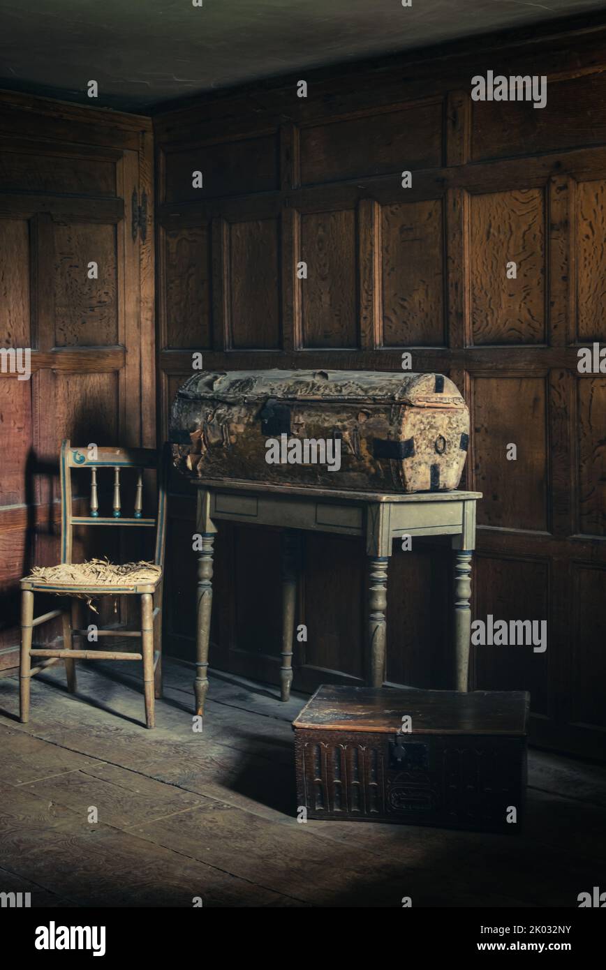 Una cassa storica di viaggi e denaro in una camera con pannelli in legno in un palazzo dell'Oxfordshire. Foto Stock