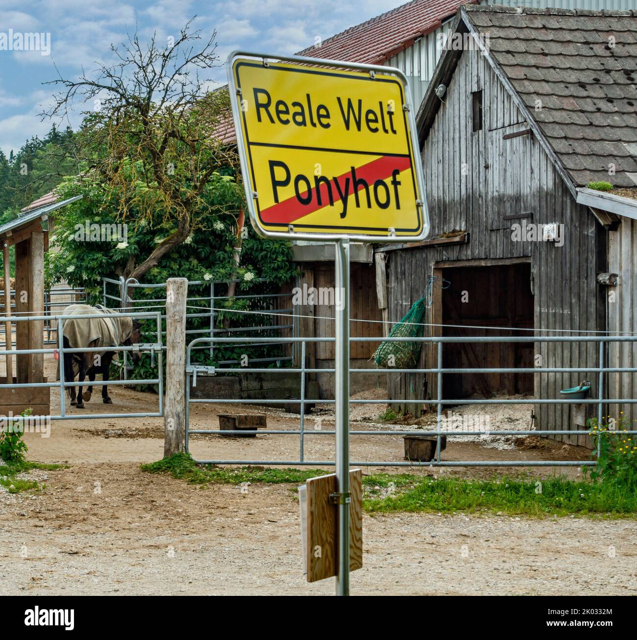 Luogo nome segno Real World, qui finisce la fattoria pony. Il cartello si trova di fronte alle scuderie delle fattorie Fauserhöhe vicino a Münsingen. Foto Stock