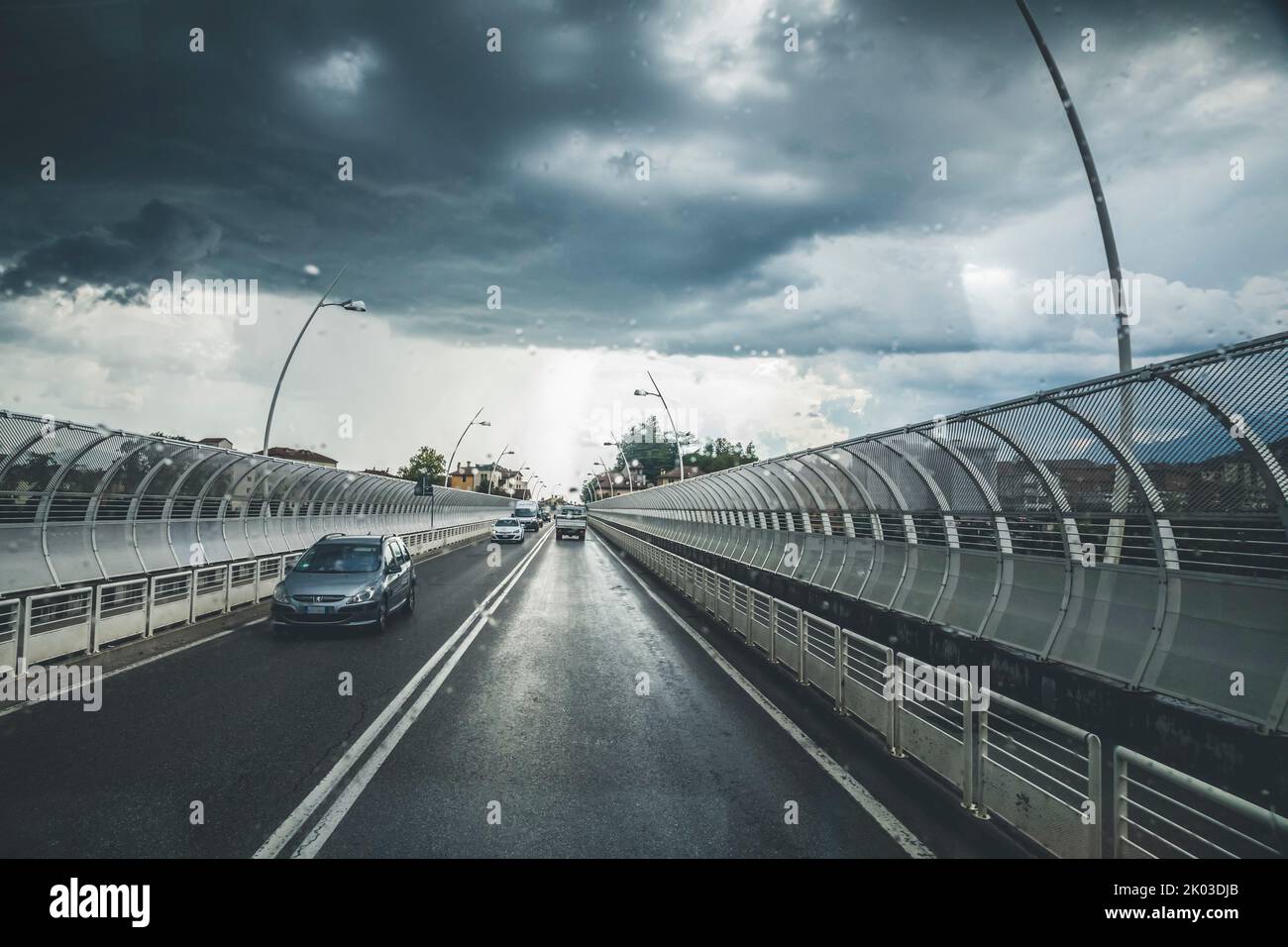 Italia, Veneto, Belluno. Vista sulla strada dall'interno di un'auto, con cielo spettacolare e temporale imminente Foto Stock