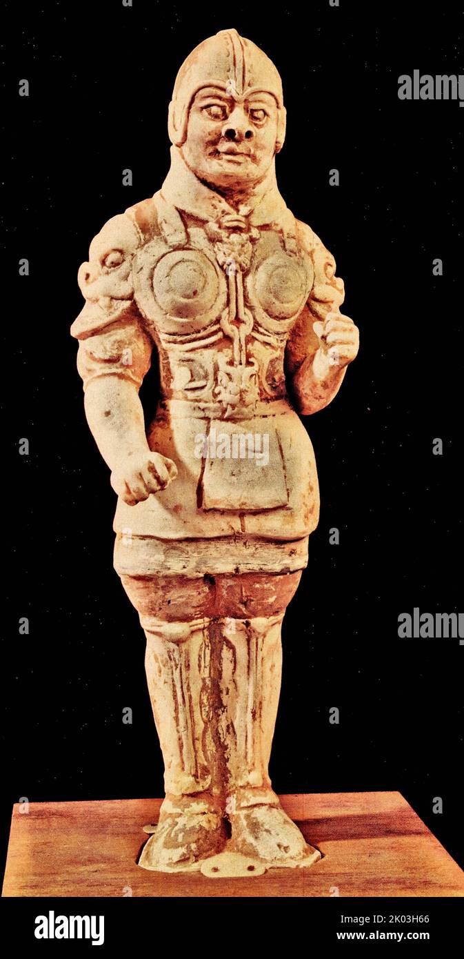 Tang Dynasty figurina bianca, ufficiale il cui corpo ha solo tracce dipinte di rosso, bianco e nero, in piedi in verticale sulla piattaforma, la piattaforma è disabile. Il figurino indossa un casco rotondo e un'armatura, la testa è girata a sinistra, le mani sono arroccate in pugni e le sue espressioni facciali sono serie. I modelli sulla sua armatura sono evidenti, e ci sono copricapo animali sulle spalle e sul petto. Il suo modo imponente è estremamente maestoso. E' un'opera realistica nella prima Dinastia Tang. Foto Stock