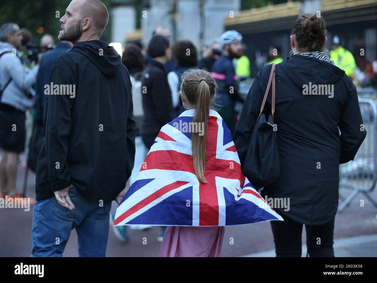 Londra, Regno Unito. 09th Set, 2022. Una giovane ragazza indossa una bandiera sindacale come un capo mentre lei e i suoi genitori vengono a pagare i loro rispetti alla regina alle porte di Buckingham Palace. Sua Maestà la Regina Elisabetta II è morta al Castello di Balmoral all'età di 96 anni, avendo regnato sul Regno Unito per 70 anni. Credit: SOPA Images Limited/Alamy Live News Foto Stock