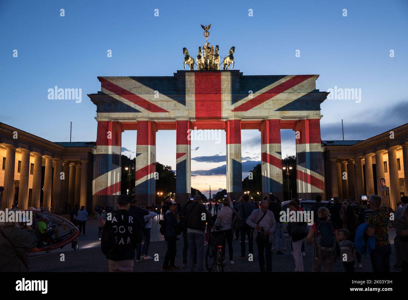 Nella capitale tedesca di Berlino, la porta di Brandeburgo è stata illuminata con la bandiera dell'Unione la sera del 9 settembre 2022, in lutto della regina Elisabetta II Molte persone si sono riunite a Pariser Platz per esprimere la loro solidarietà. La regina Elisabetta II aveva guidato attraverso la porta di Brandeburgo nel 2015 con il principe Filippo nella sua limousine dopo aver detto Arrivederci a Pariser Platz. La regina Elisabetta II arrivò per la prima volta a Berlino, che era ancora divisa all'epoca, nel 1965, come primo capo di stato britannico dopo la seconda guerra mondiale, dove fu accolta da un pubblico di almeno un milione di persone. A quel tempo, lei no Foto Stock