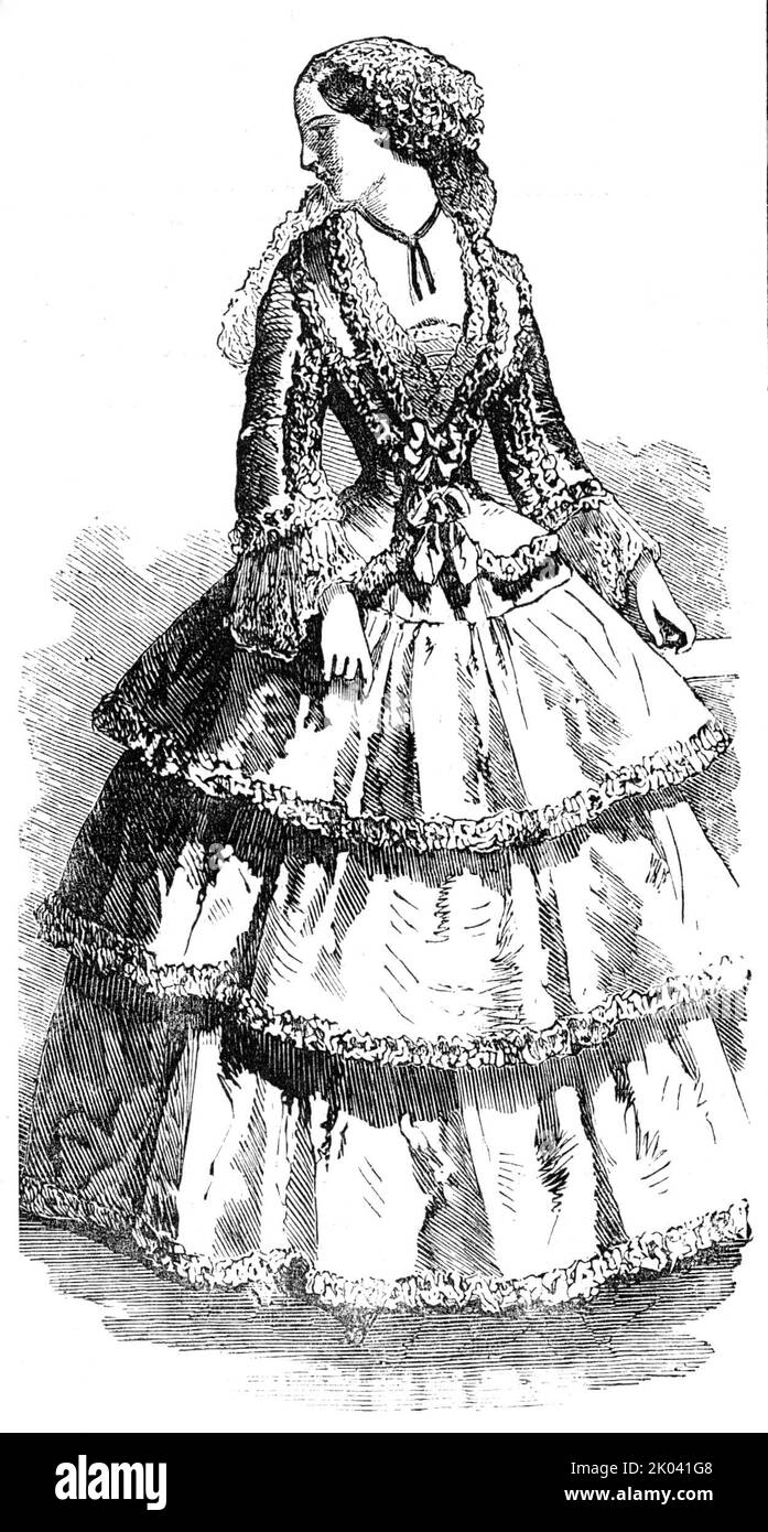 Parigi Moda per il nuovo anno, 1854. 'Lace Cap en point d'Alencon, con gruppi di fiori su ogni lato; a volte, invece di questi gruppi, i fiori sono posti in una corona, a partire dal centro della testa, continuando a crescere sulle guance, e terminando con fiori d'acqua con lunghi rametti pendenti. Questi ultimi fiori sono più particolarmente indossati con abiti a palla aperti. Accappatoio de satin turc, con baschi, ornato da una frangia muschiosa, finendo davanti al corsage, e formando un bretelle. Fichu e maniche in pizzo, simili al cofano; l'interno della manica è rifinito con una doppia Foto Stock