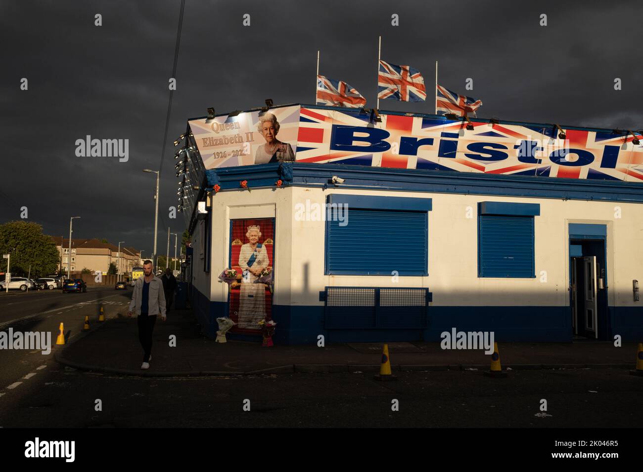 Glasgow, Scozia, 9 settembre 2022. Il Bristol Bar, uno dei preferiti dai sostenitori dell'Unionist e del Rangers FC, mostra un ritratto della Regina Elisabetta II e vola bandiere a metà albero, come segno di rispetto per sua Maestà, che è morta a 96 anni, a Glasgow, Scozia, il 9 settembre 2022. Photo credit: Jeremy Sutton-Hibbert/ Alamy Live news. Foto Stock
