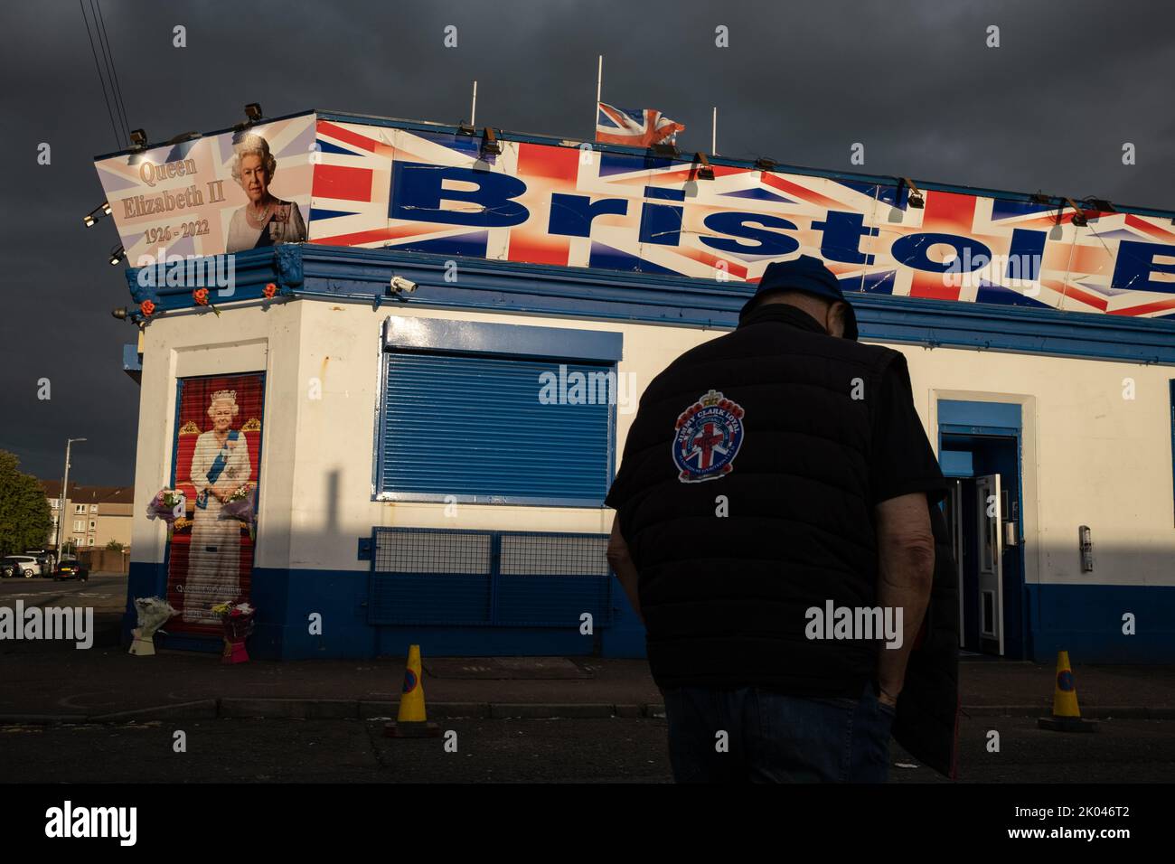 Glasgow, Scozia, 9 settembre 2022. Il Bristol Bar, uno dei preferiti dai sostenitori dell'Unionist e del Rangers FC, mostra un ritratto della Regina Elisabetta II e vola bandiere a metà albero, come segno di rispetto per sua Maestà, che è morta a 96 anni, a Glasgow, Scozia, il 9 settembre 2022. Photo credit: Jeremy Sutton-Hibbert/ Alamy Live news. Foto Stock
