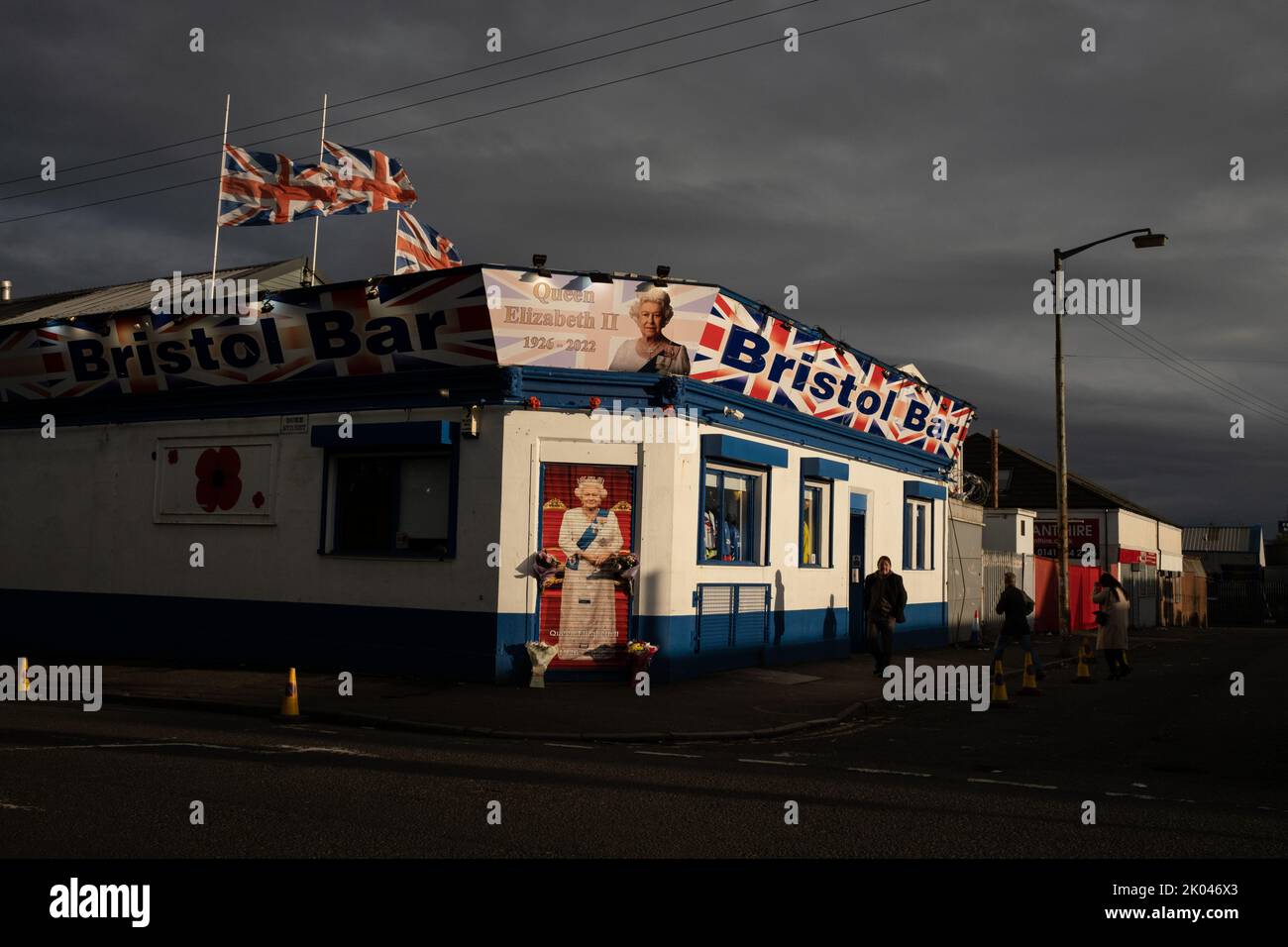 Glasgow, Scozia, 9 settembre 2022. Il Bristol Bar, uno dei preferiti dai sostenitori dell'Unionist e del Rangers FC, mostra un ritratto della Regina Elisabetta II e vola bandiere a metà albero, come segno di rispetto per sua Maestà, che è morta a 96 anni, a Glasgow, Scozia, il 9 settembre 2022. Photo credit: Jeremy Sutton-Hibbert/ Alamy Live news. Foto Stock
