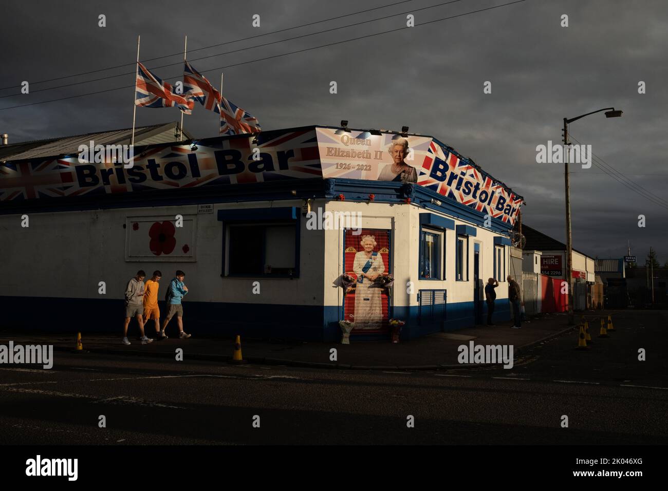 Glasgow, Scozia, 9 settembre 2022. Il Bristol Bar, uno dei preferiti dai sostenitori dell'Unionist e del Rangers FC, mostra un ritratto della Regina Elisabetta II e vola bandiere a metà albero, come segno di rispetto per sua Maestà, che è morta a 96 anni, a Glasgow, Scozia, il 9 settembre 2022. Photo credit: Jeremy Sutton-Hibbert/ Alamy Live news. Foto Stock