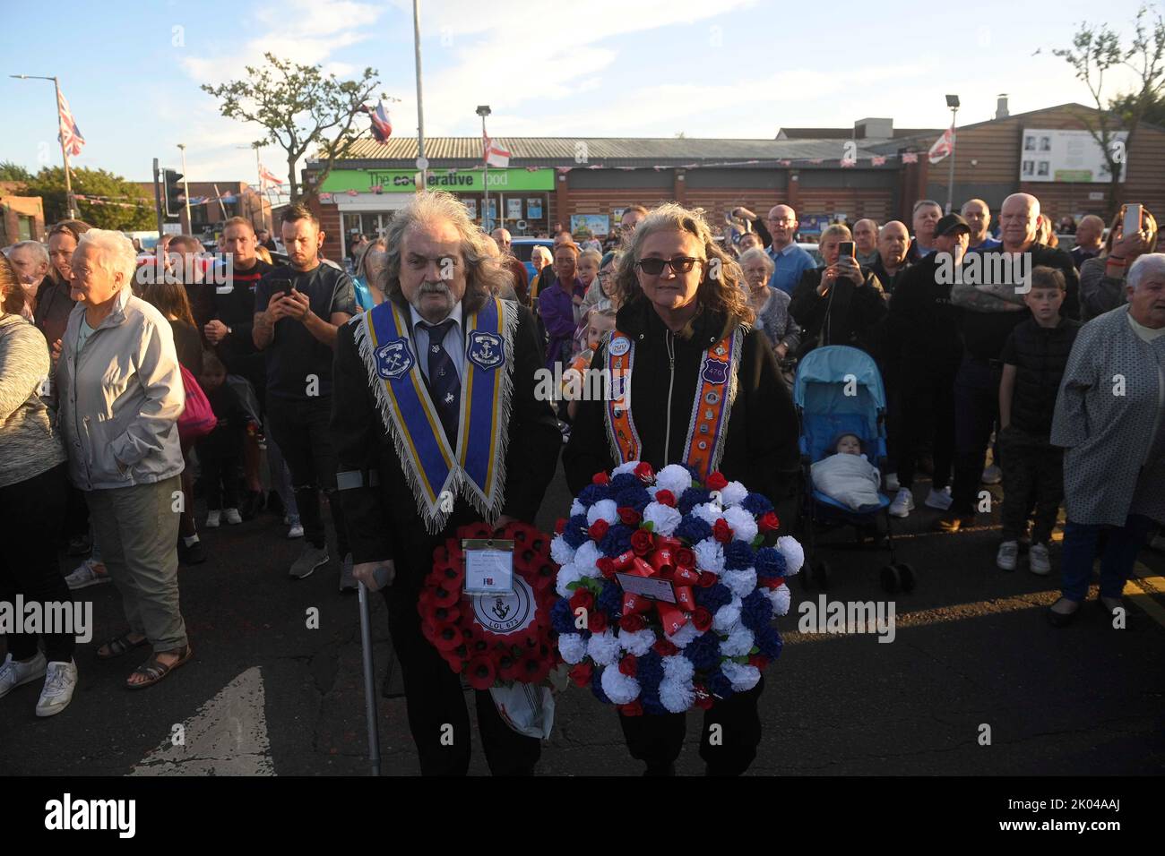 Bande lealiste e membri del pubblico vengono a piangere la perdita della Regina Elisabetta II sulla Shankill Road di Belfast. Data immagine: Venerdì 9 settembre 2022. Foto Stock