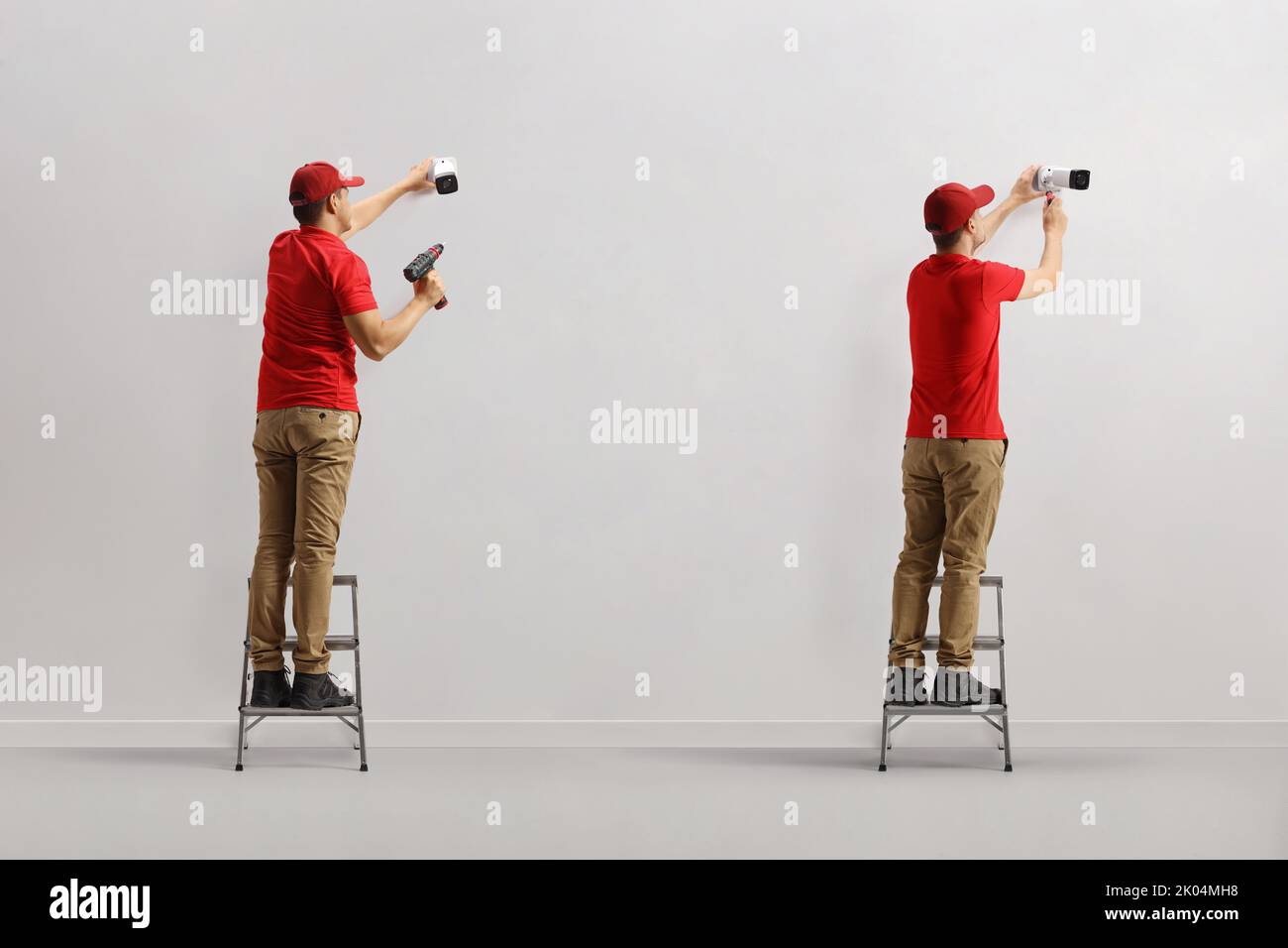 Lavoratori che installano telecamere di sicurezza a parete Foto Stock