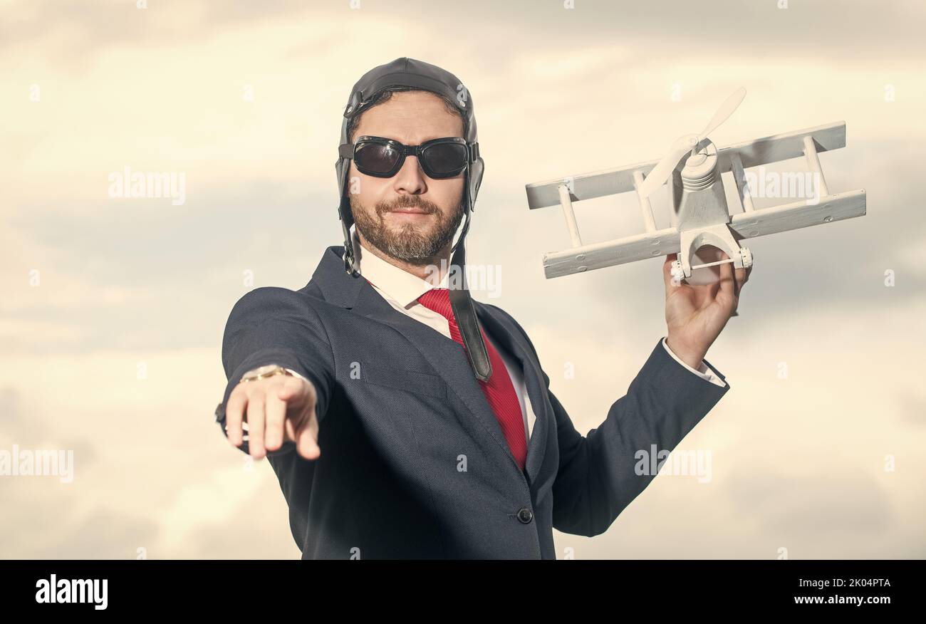 uomo d'affari in abito e cappello pilota lancia giocattolo aereo. regia Foto Stock