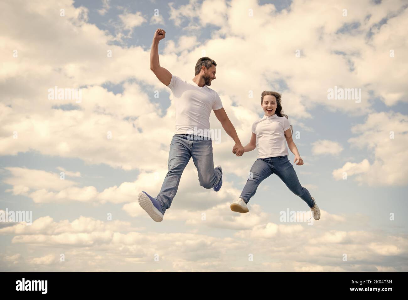 felice padre e figlia saltano in cielo Foto Stock
