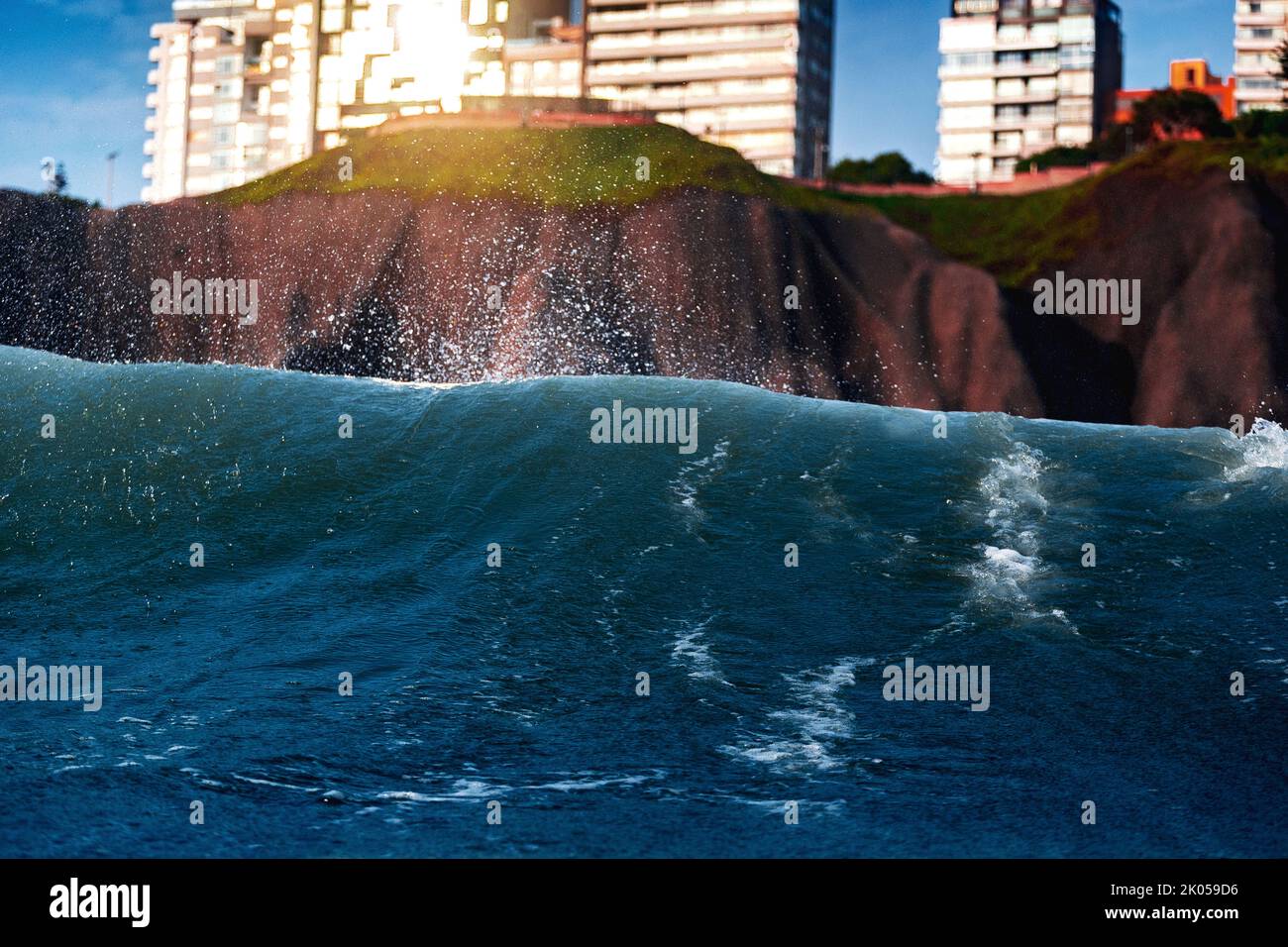 Scogliera con edifici Malecon de Miraflores visto dal mare con le onde in una giornata di sole Foto Stock
