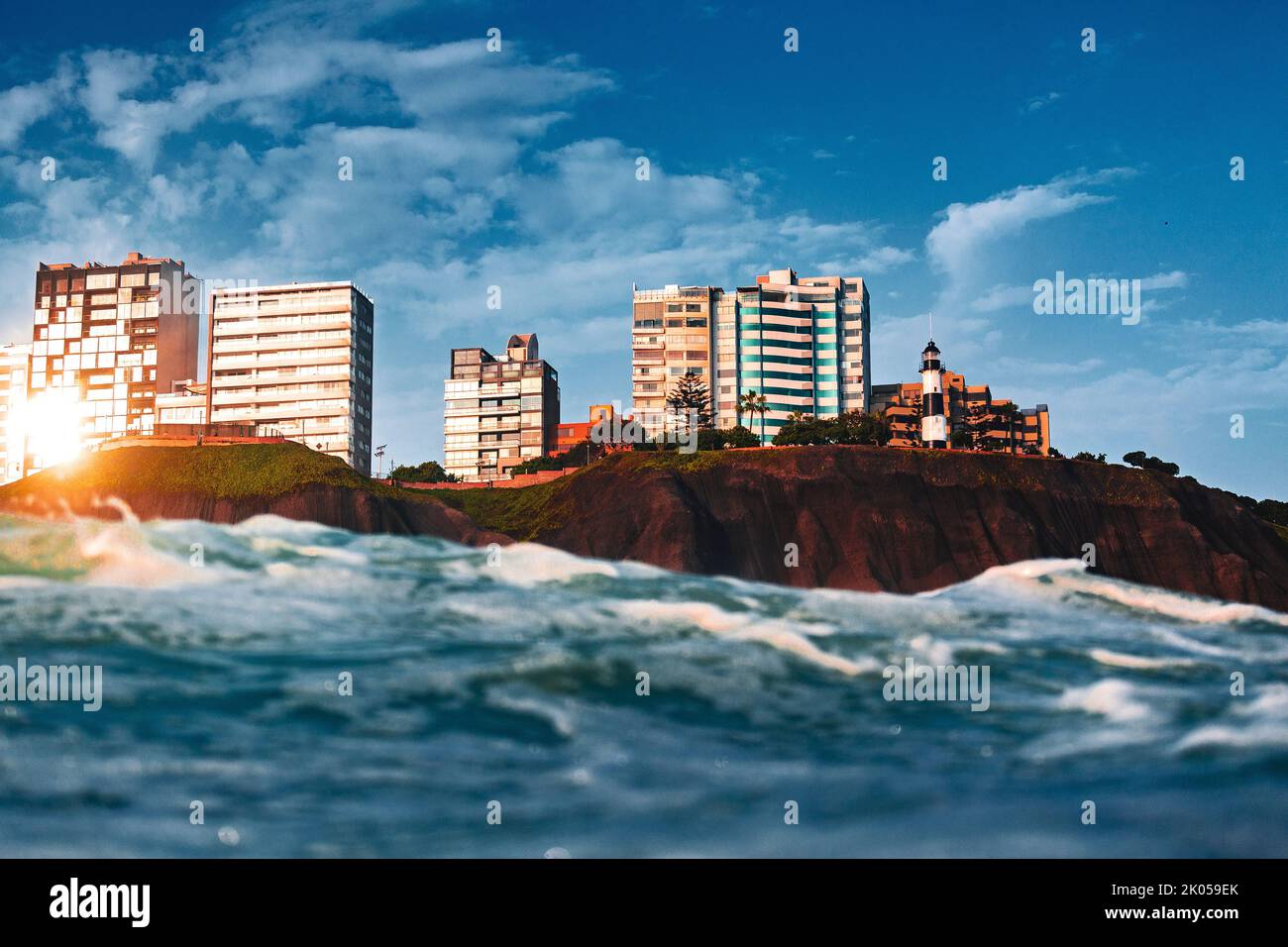 Scogliera con edifici Malecon de Miraflores visto dal mare con le onde in una giornata di sole Foto Stock