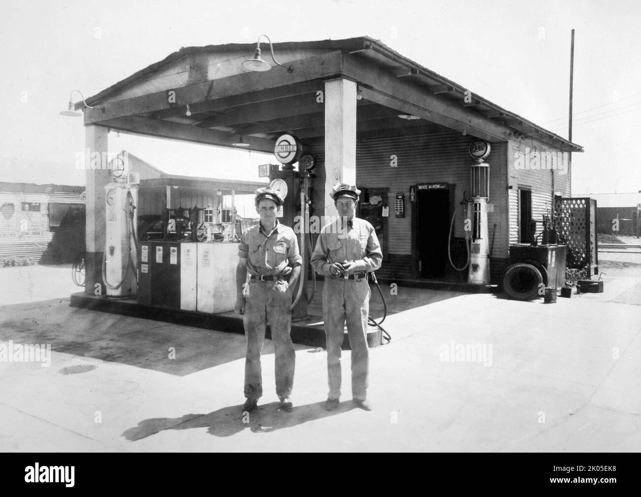 Gli assistenti di Humble Oil Co. Si trovano di fronte a una stazione di servizio Humble in Texas, circa 1935. Foto Stock