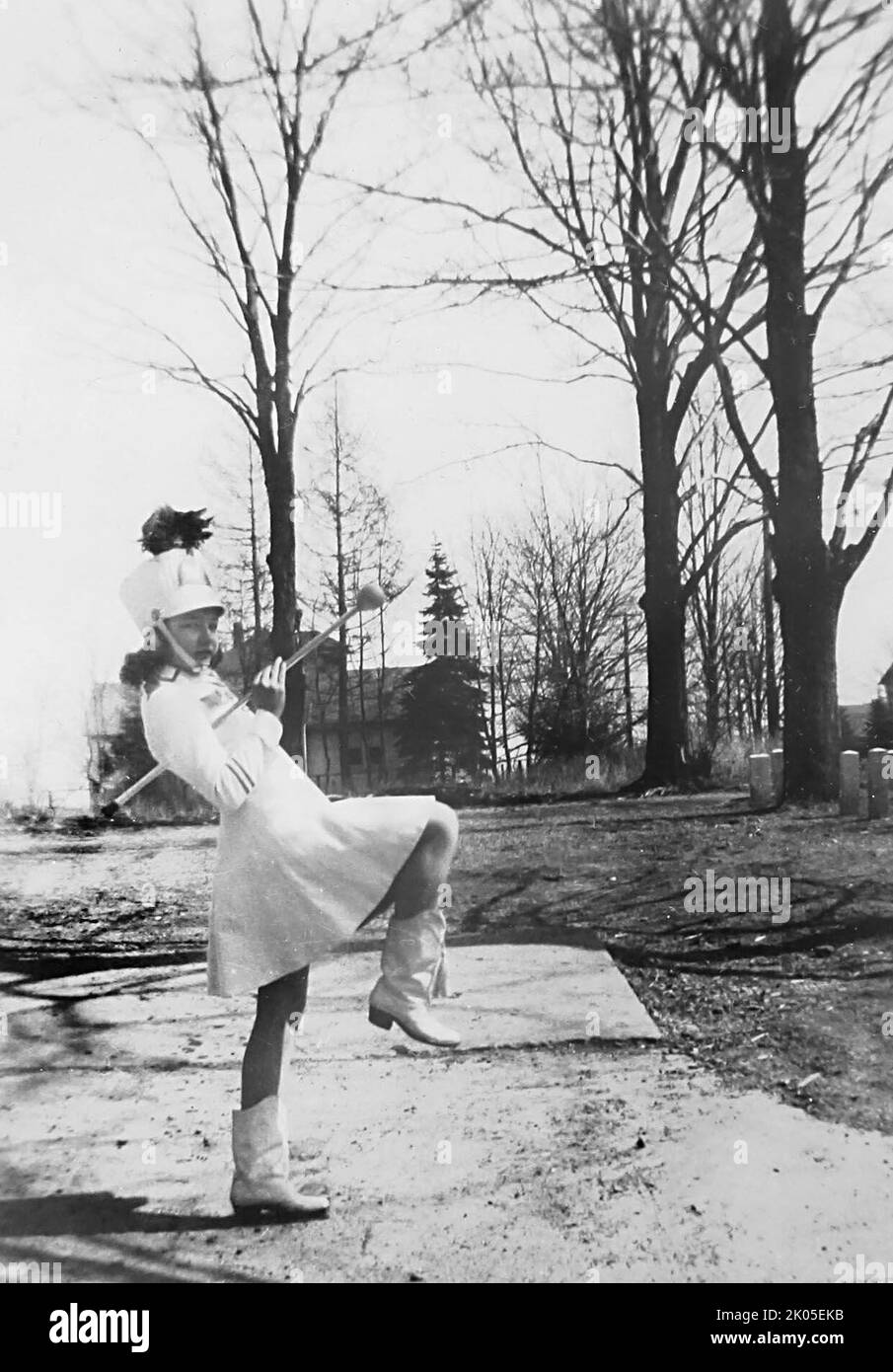 Una ragazza giovane pratica la sua majorette alto-passo, ca. 1945. Foto Stock