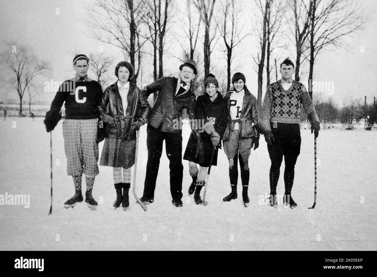 Un gruppo di giovani adulti è pronto per l'inverno sul ghiaccio, ca. 1925. Foto Stock