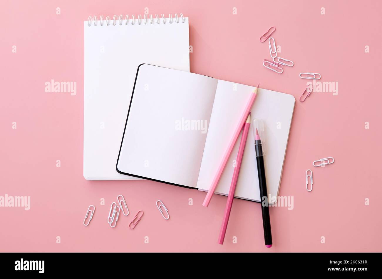 Torna a scuola forniture di notebook aperto su sfondo rosa, piatto, spazio copia. Foto Stock