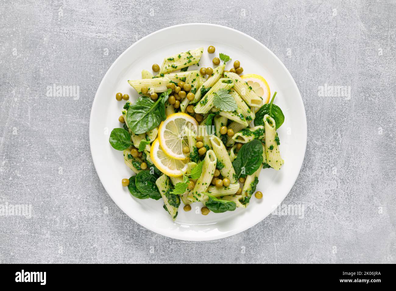 Penne di pasta con pesto di spinaci e piselli verdi Foto Stock