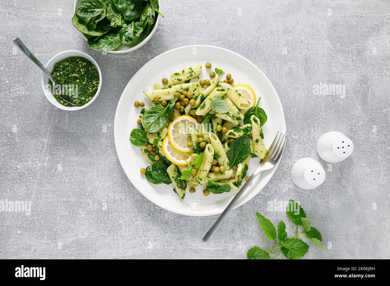 Penne di pasta con pesto di spinaci e piselli verdi Foto Stock
