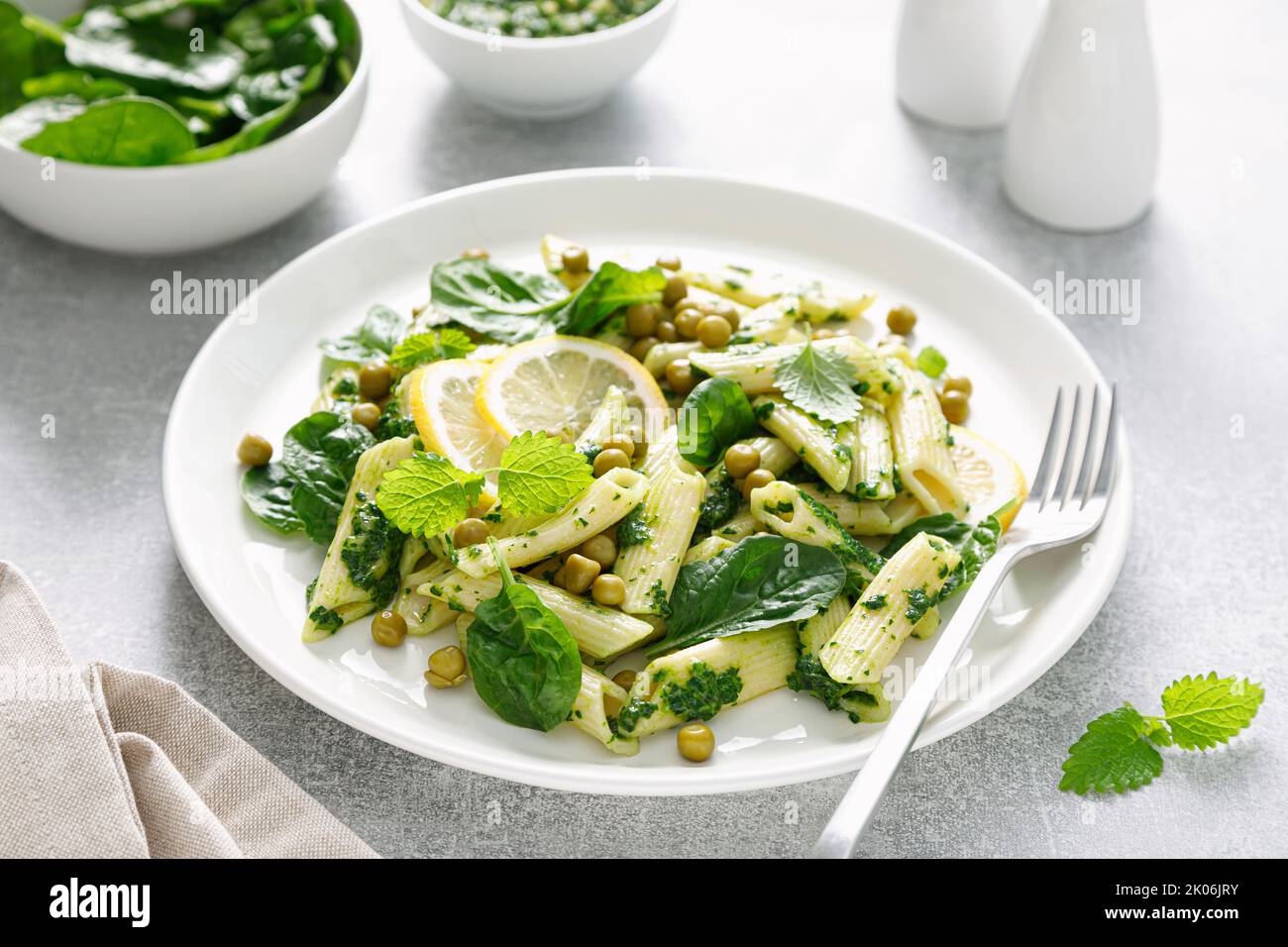 Penne di pasta con pesto di spinaci e piselli verdi Foto Stock
