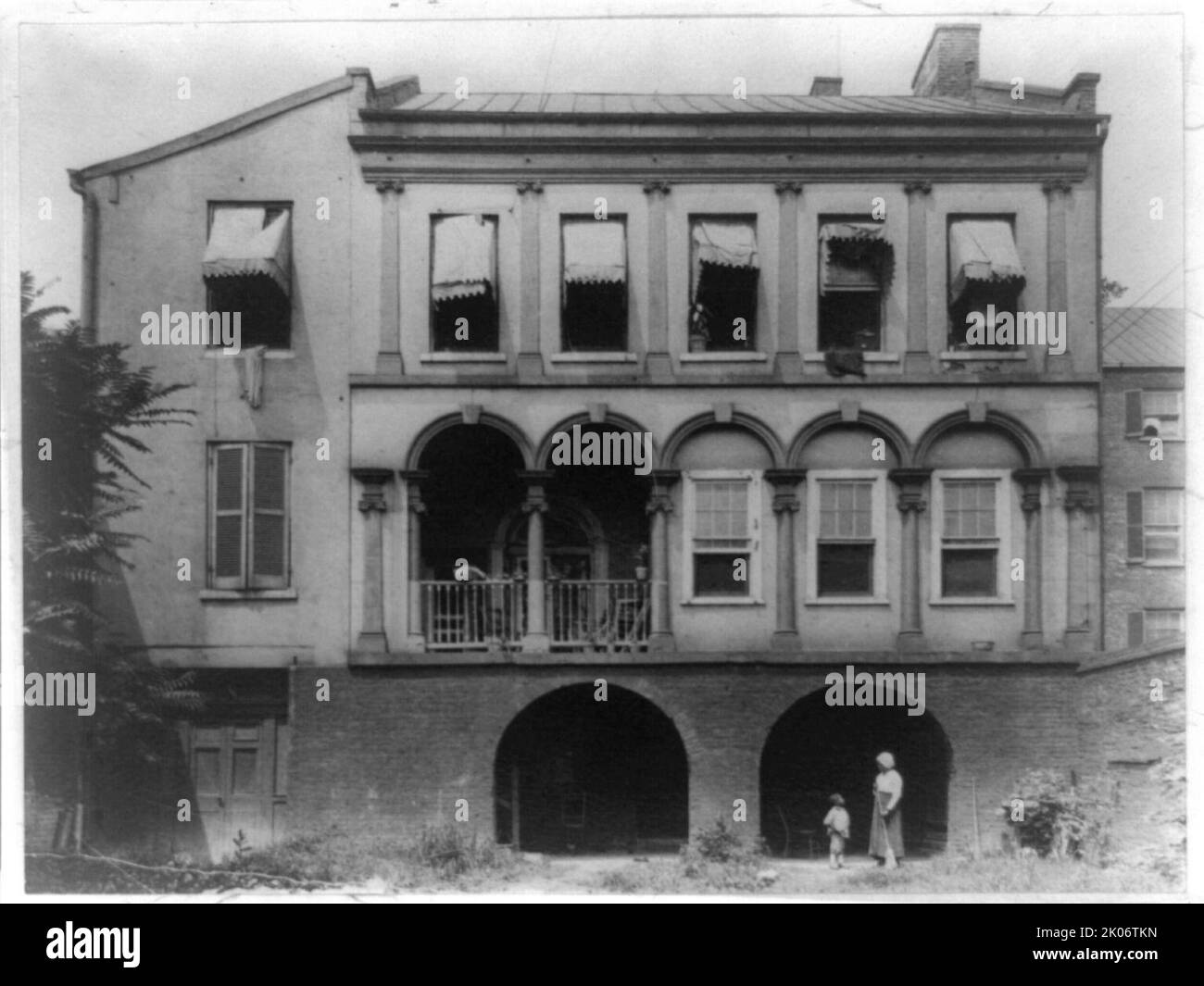 James Holloway Loggia School, Fairfax St. Tra Cameron e Queen, Alexandria, Virginia, 1918. Donna afroamericana con scopa e ragazzo sotto l'arco. Foto Stock