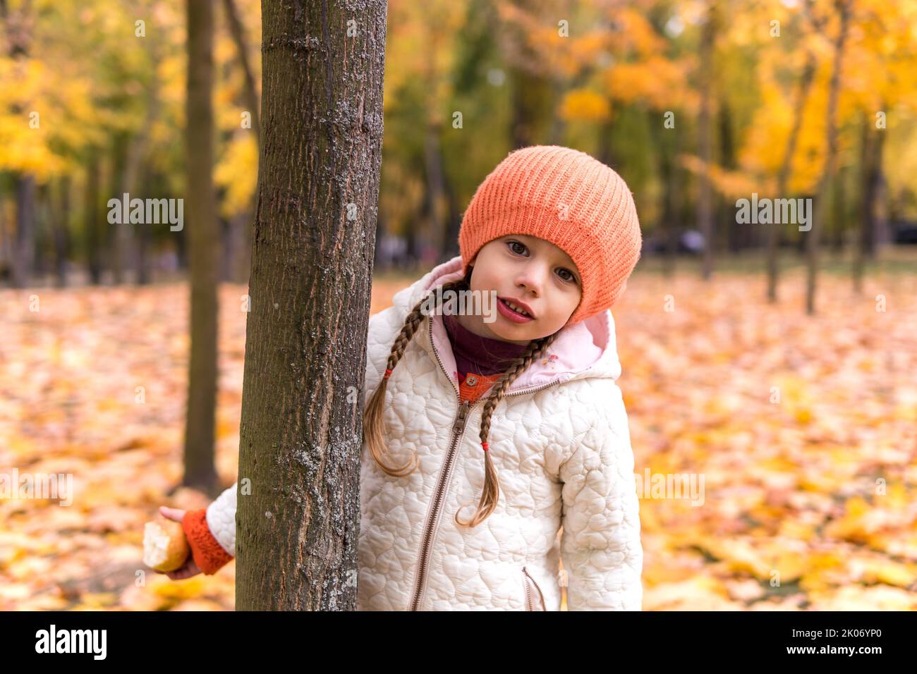 Un bambino felice e divertente ragazza cappello orande camminare nel parco foresta godendo autunno autunno caduta natura tempo. Fratelli Kid raccogliere foglie in caduta nei cestini Foto Stock