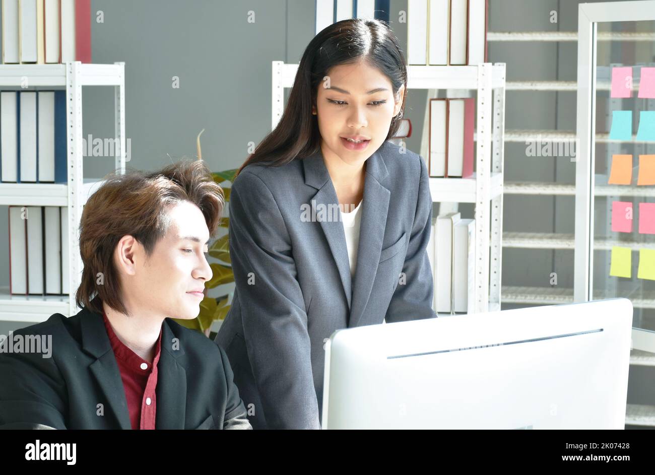Uomo e donna asiatica d'affari che guarda lo schermo del computer portatile per discutere e lavorare in ufficio Foto Stock