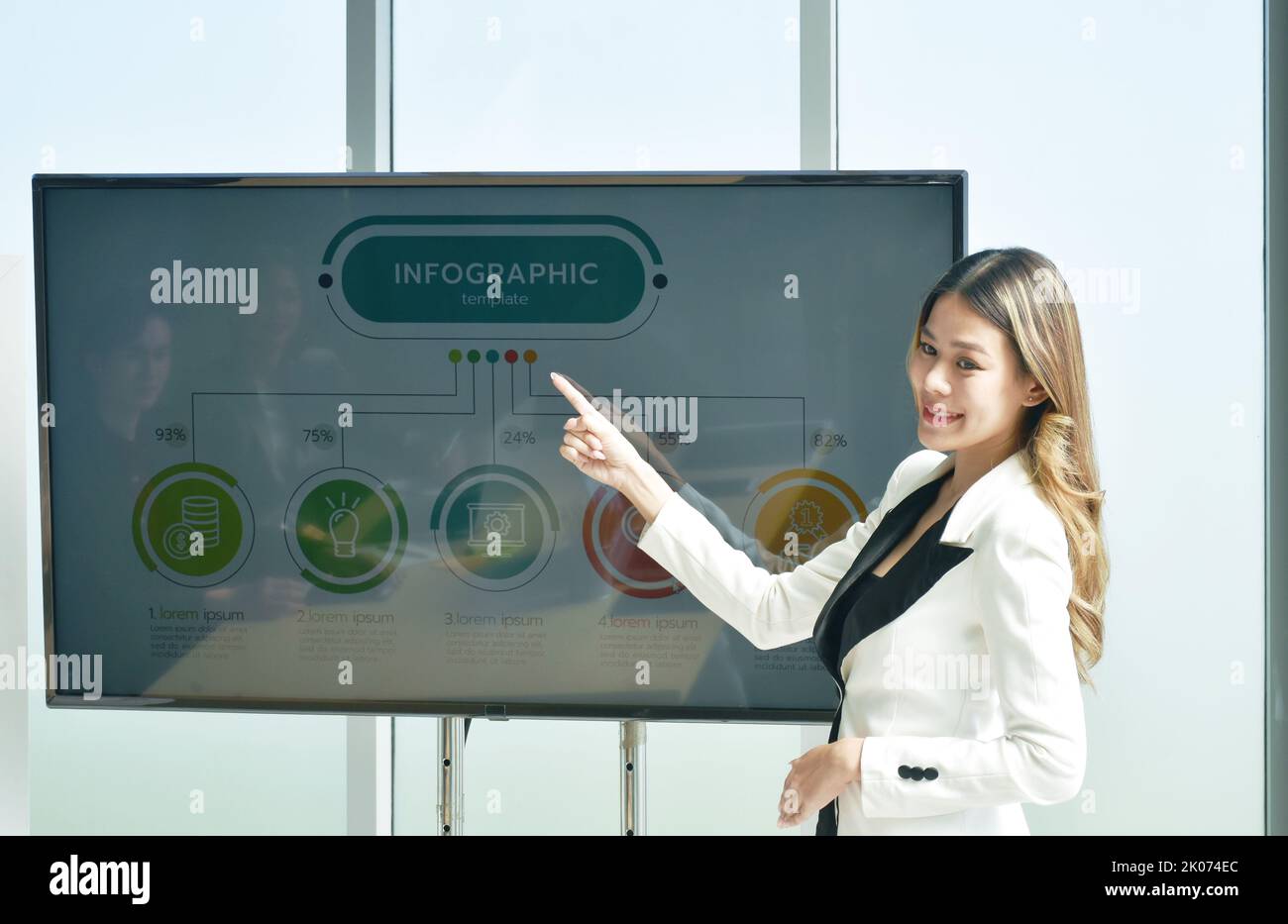Donna d'affari Asiatica di bellezza che presenta il lavoro sullo schermo televisivo nella sala riunioni dell'ufficio Foto Stock