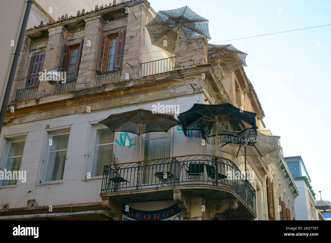 Vecchio edificio in rovina con ombrello sul balcone vicino a Monastiraki ad Atene, Grecia Foto Stock
