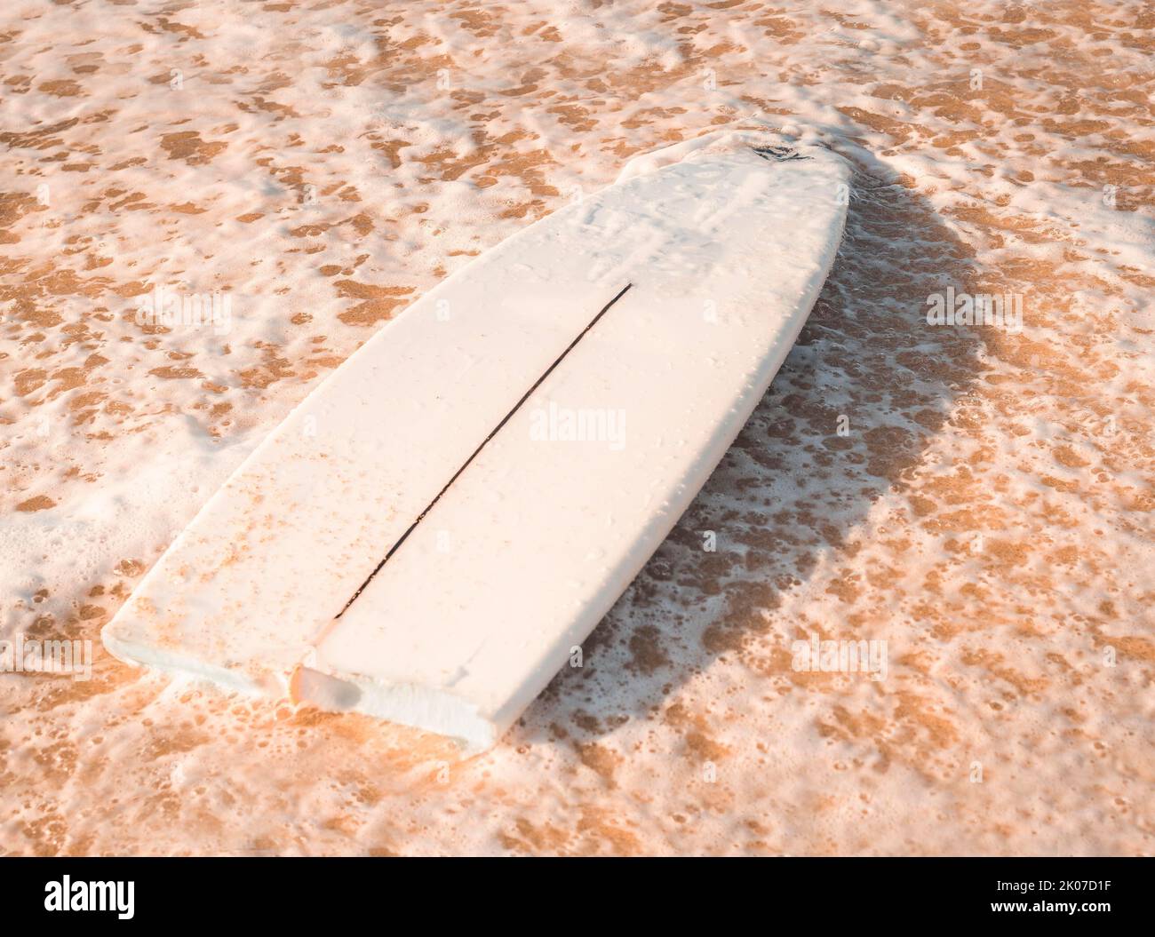Una tavola da surf rotta sulla sabbia in spiaggia. Concetto di surf Foto Stock