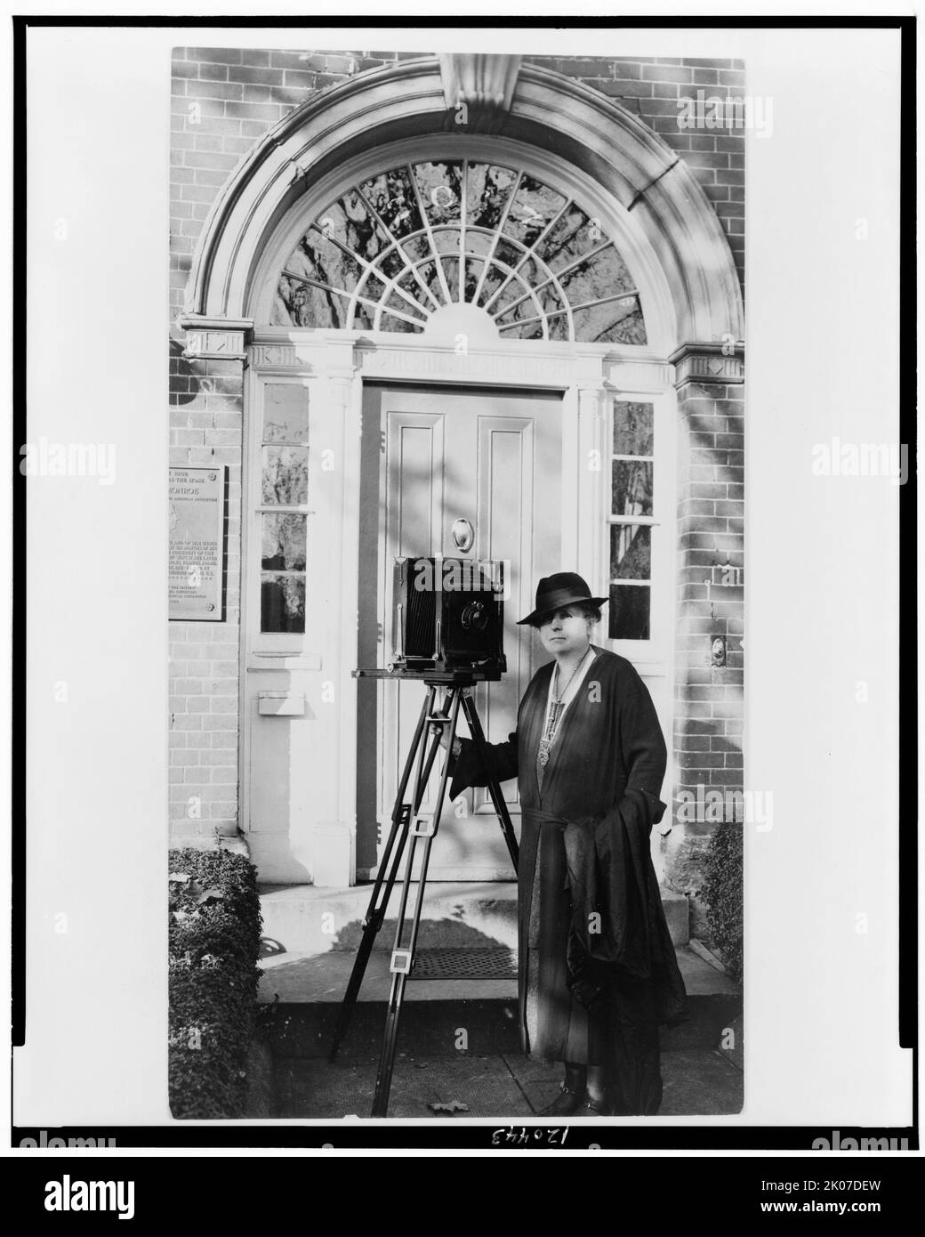 Frances Benjamin Johnston, ritratto completo, in piedi davanti alla porta, con fotocamera, rivolto leggermente a sinistra, c1935. Foto Stock
