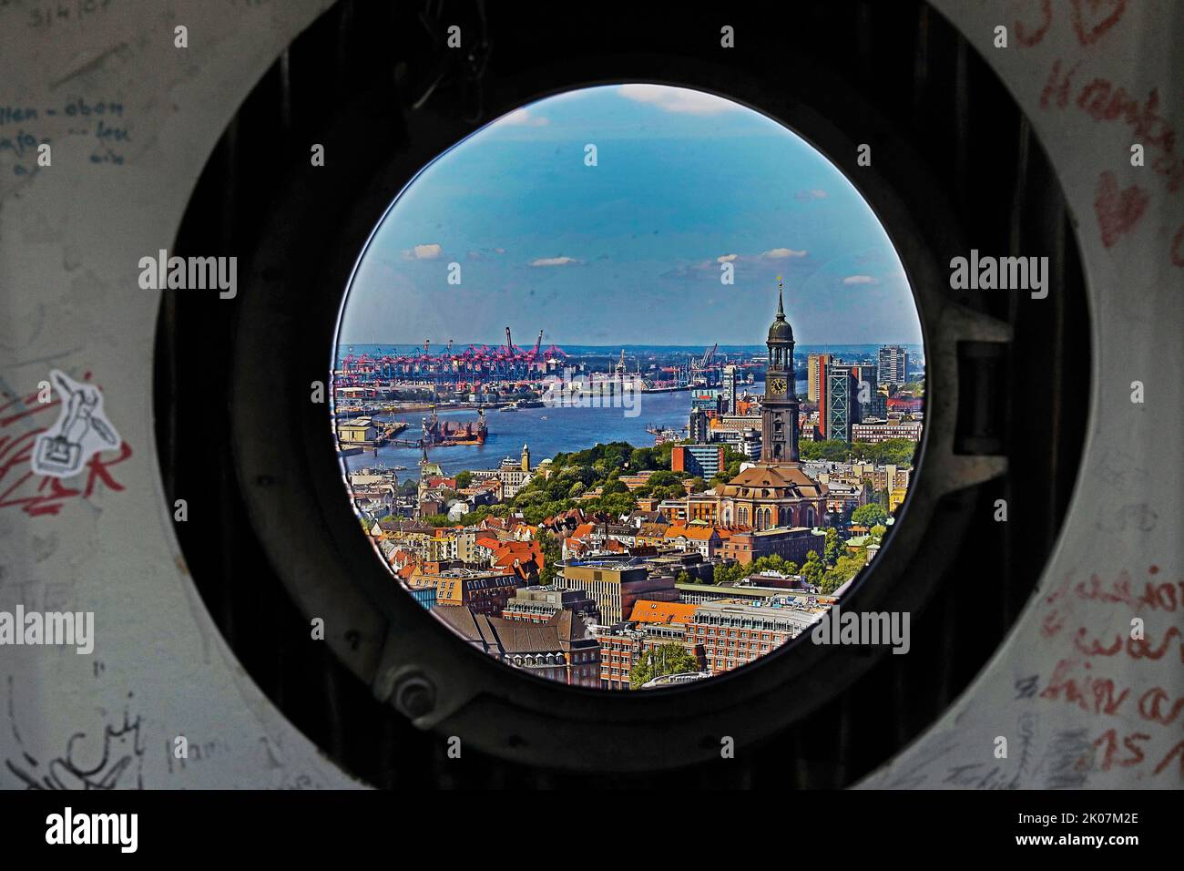 Vista della città con il Michel e il porto attraverso le finestre oblò nella guglia della chiesa principale di San Petri, Amburgo, Germania Foto Stock