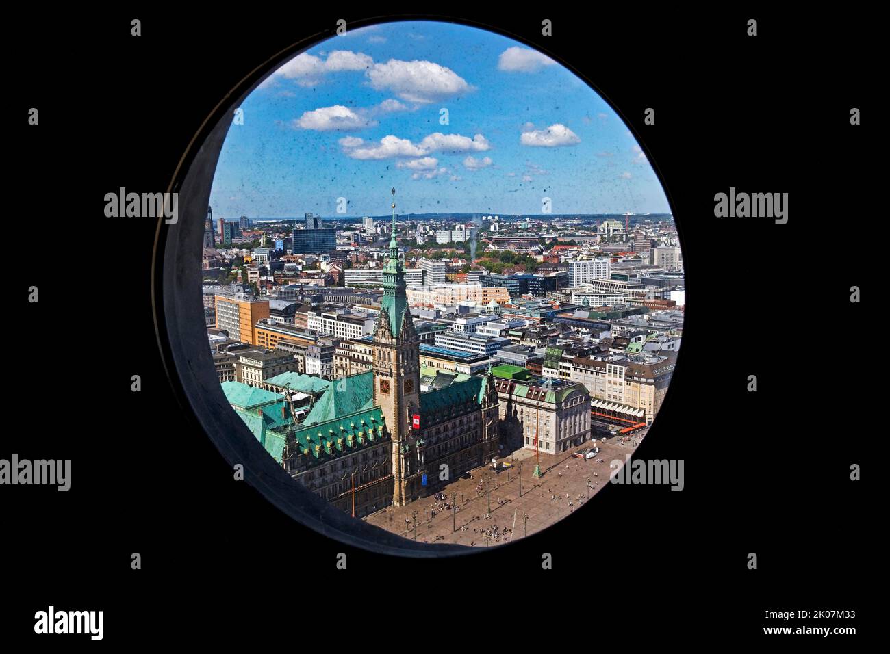 Vista sulla città con il municipio attraverso le finestre a oblò nella guglia della chiesa principale di San Petri, Amburgo, Germania Foto Stock