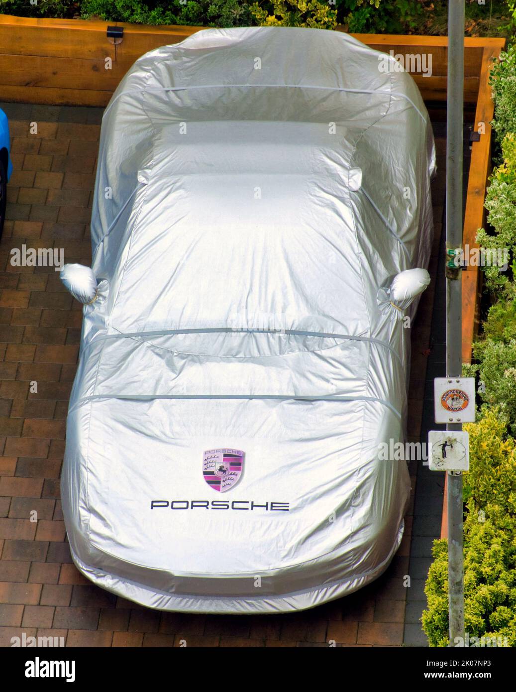Porsha auto sotto copertura argentata con logo sulla strada Foto Stock