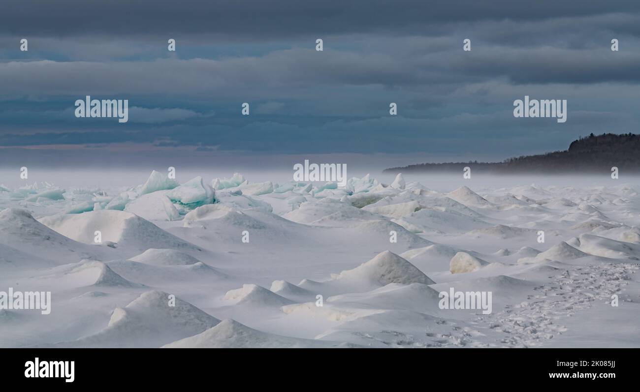 Il vento sta soffiando la neve sulla superficie della Green Bay, le zacchette di ghiaccio del lago Michigan ammorbidendo i bordi taglienti del ghiaccio e creando un altro mondo Foto Stock