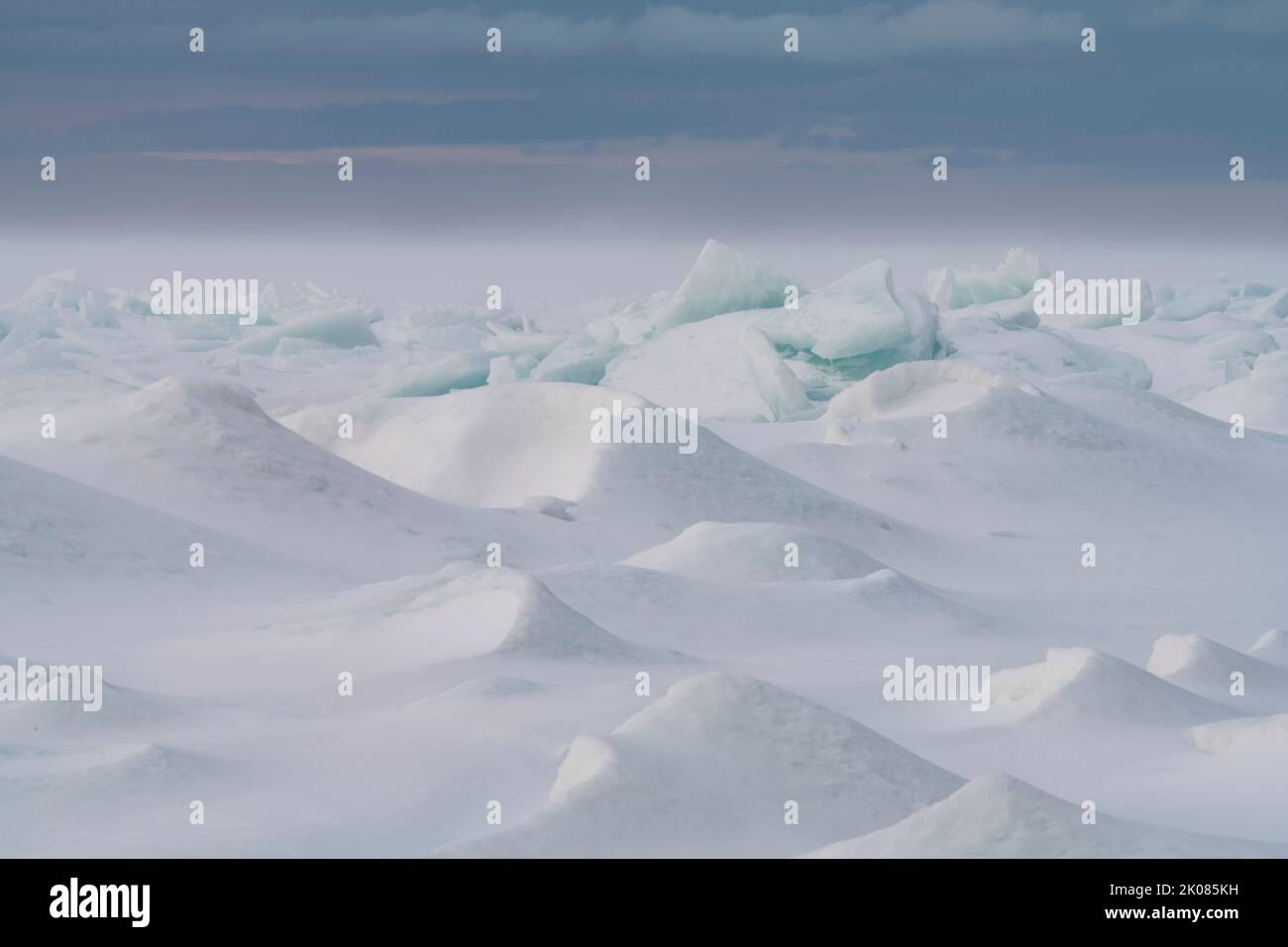 Il vento sta soffiando la neve sulla superficie della Green Bay, le zacchette di ghiaccio del lago Michigan ammorbidendo i bordi taglienti del ghiaccio e creando un altro mondo Foto Stock