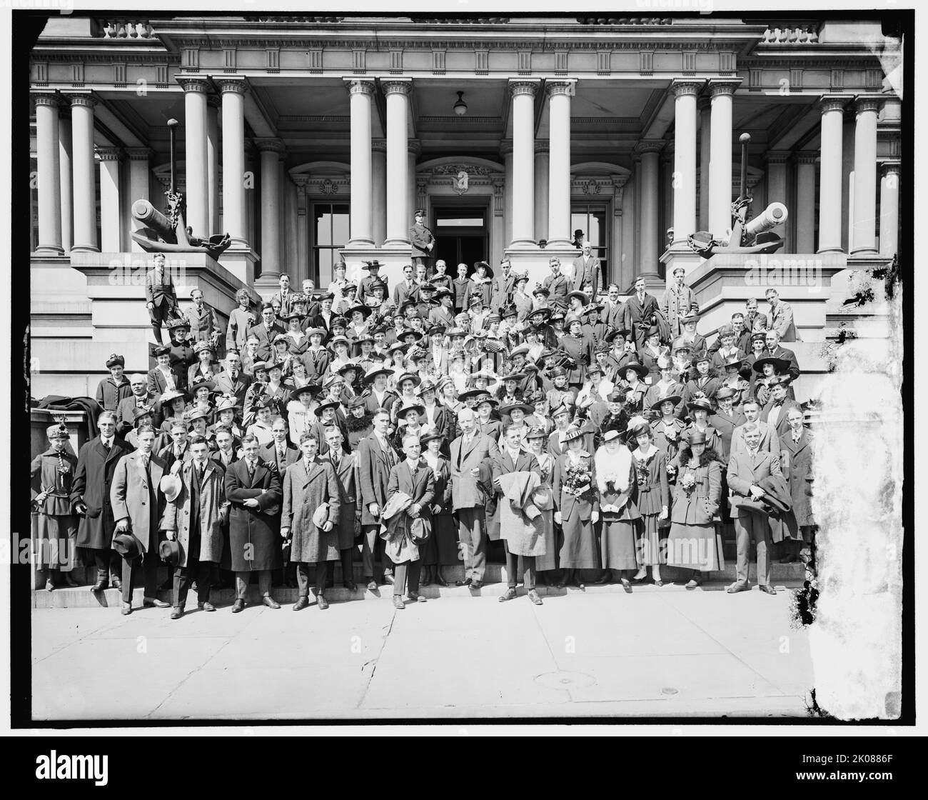 Gruppo Detroit, tra il 1910 e il 1920. Uomini e donne posarono su gradini fuori dello Stato, Guerra e Navy Building (ribattezzato Eisenhower Executive Office Building), Washington, D.C.. Nota sculture di ancore e cannone. Foto Stock