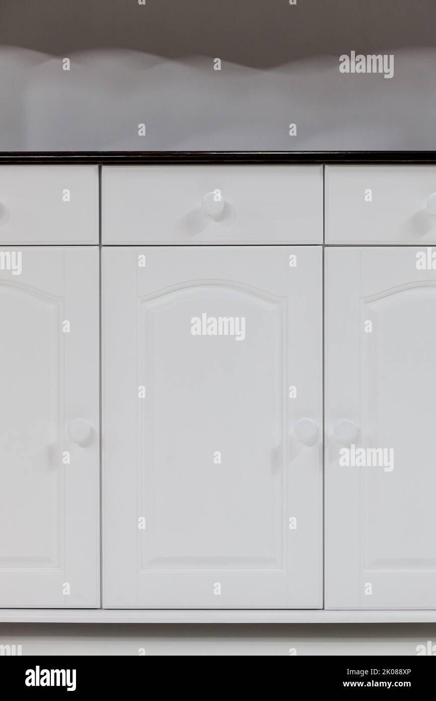 Chiudere le porte di un mobile da cucina bianco. Mobili da cucina classici in legno naturale. Foto Stock