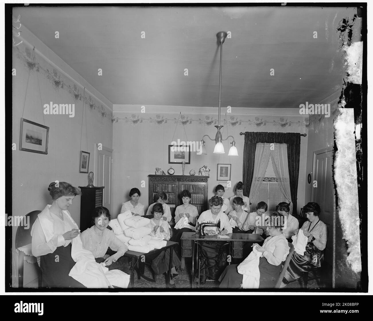 Sig.ra Ball e gruppo presso l'Hamilton Hotel, tra le 1910 e le 1920. Donne cucire, USA. Si utilizza una macchina da cucire "New Home". Foto Stock