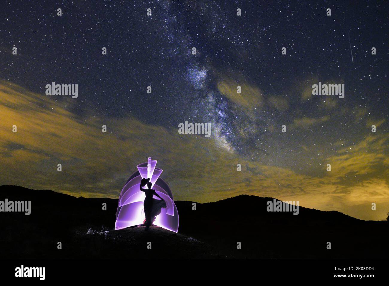 Fotografia notturna, pittura luminosa con il modo lattiginoso sullo sfondo. Foto Stock