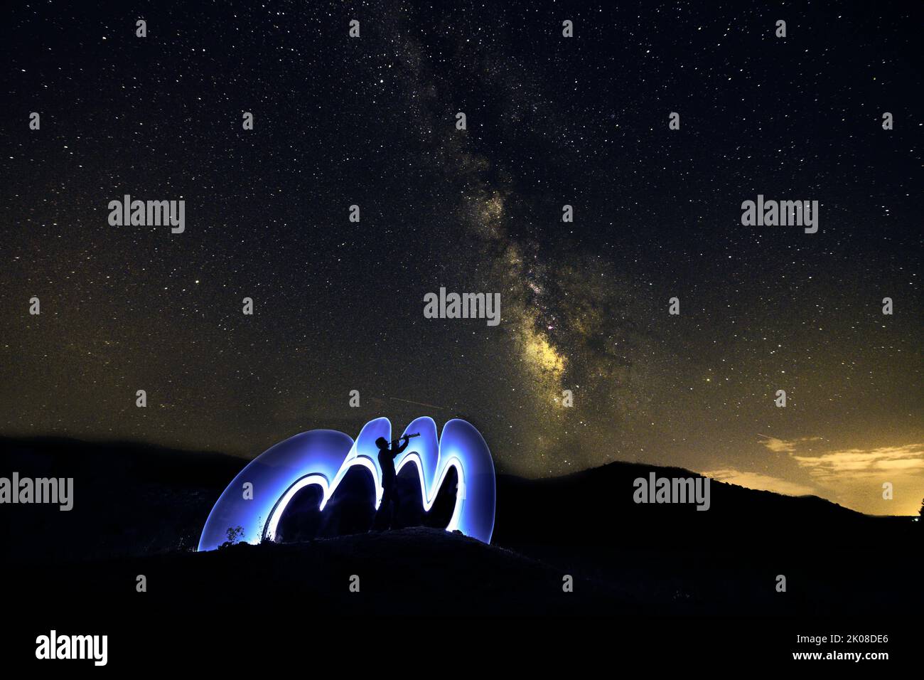 Fotografia notturna, pittura luminosa con il modo lattiginoso sullo sfondo. Foto Stock