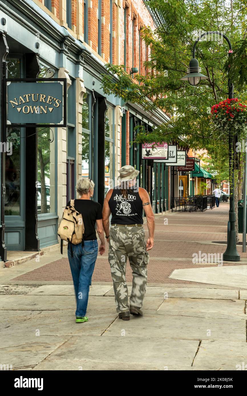 Giovane a piedi da negozi e magazzini, Città Vecchia, Fort Collins, Colorado, STATI UNITI D'AMERICA Foto Stock