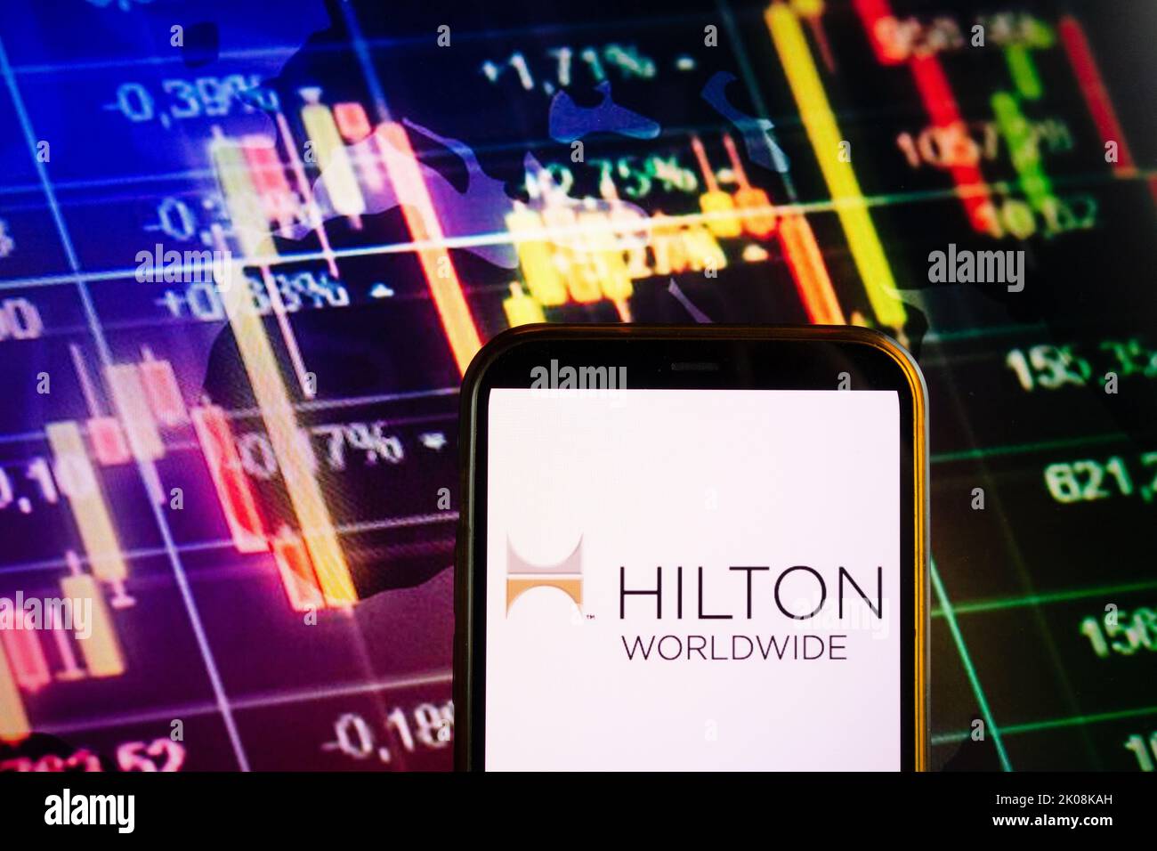 KONSKIE, POLONIA - 10 settembre 2022: Smartphone che mostra il logo della società Hilton Worldwide sullo sfondo del diagramma di borsa Foto Stock