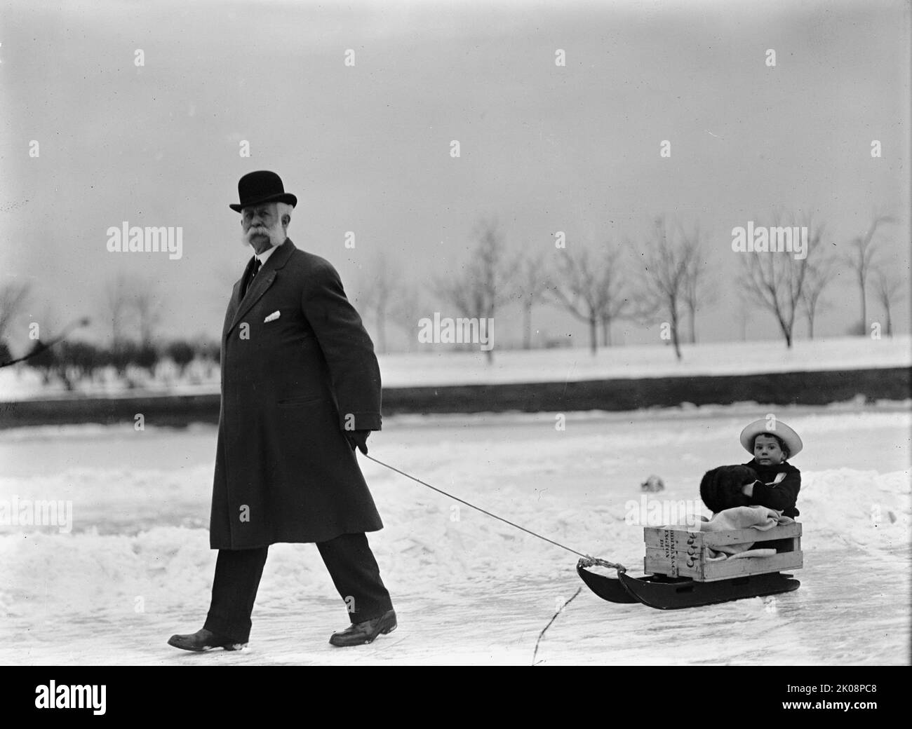 Skating Party - uomo non identificato che tira bambino su slitta, 1912. Foto Stock