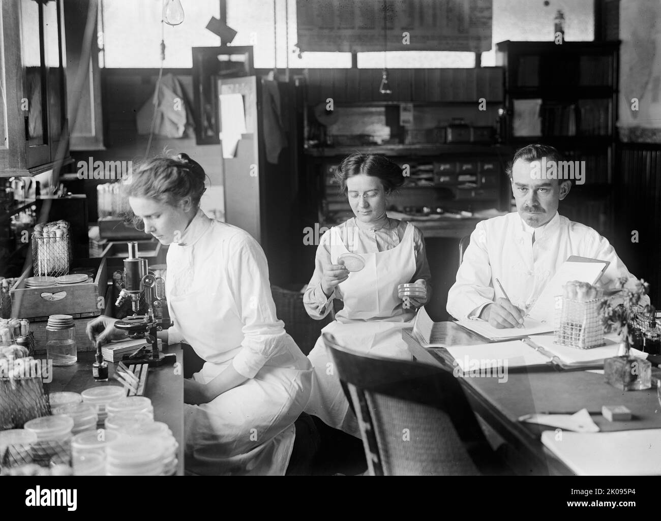 Batteriologia - Dr. George Stiles, 1912. [Due donne e un uomo in laboratorio - USA?]. Foto Stock