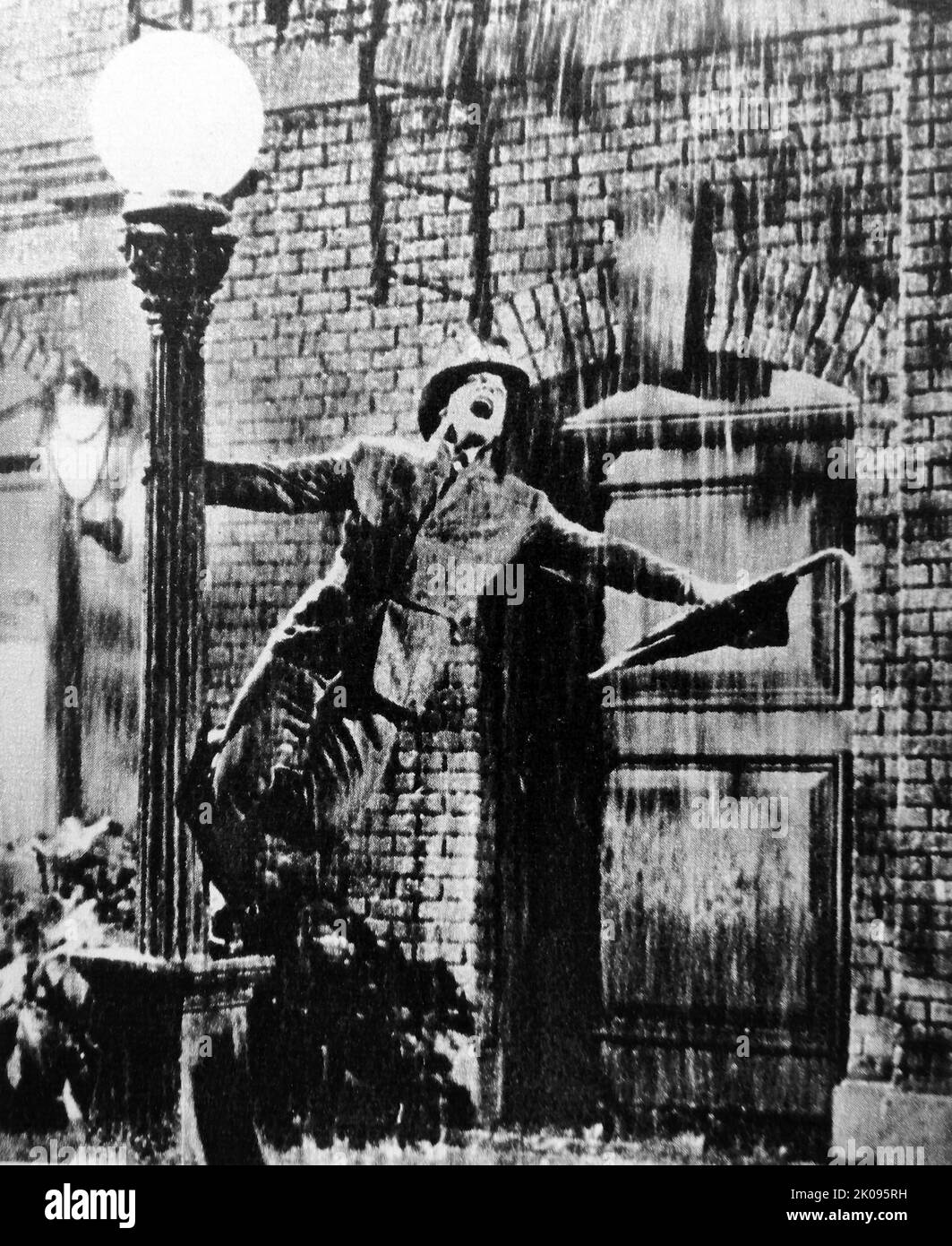 Gene Kelly in Singin' in the Rain è un film comico musicale romantico americano del 1952 diretto e coreografato da gene Kelly e Stanley Donen. Gene Kelly. Eugene Curran Kelly (23 agosto 1912 – 2 febbraio 1996) è stato un . Era conosciuto per il suo stile di ballo energico e atletico, per il suo bel look e per i personaggi simpatici che giocava sullo schermo. Foto Stock