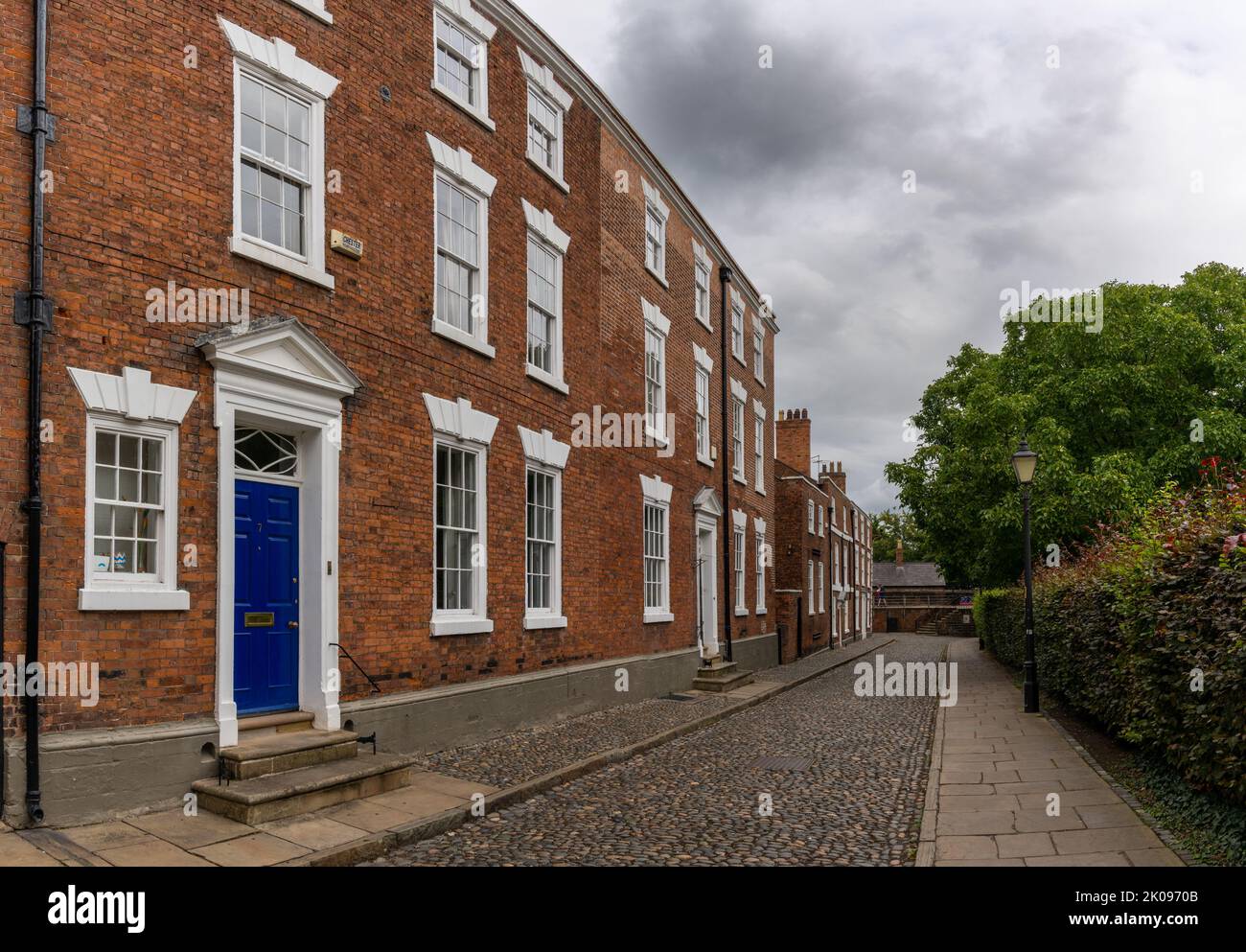 Chester, Regno Unito - 26 agosto, 2022: Edifici in mattoni rossi con porte colorate in tipico stile inglese nel centro storico di Chester Foto Stock