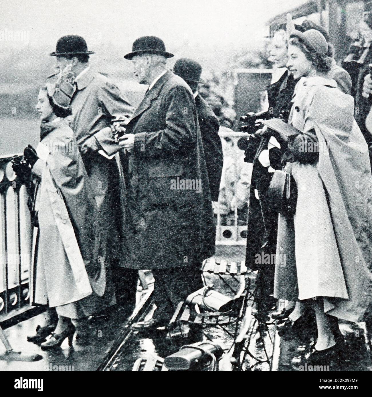 La principessa Elizabeth (a sinistra) e la principessa Margaret, nel box di Lord Sefton, guardando Monaveen, posseduta in collaborazione dalla principessa Elizabeth e la regina, corrono nel 1950 Grand National ad Aintree. Principessa Margaret, Contessa di Snowdon, ci, GCVO, CD (Margaret Rose; 21 agosto 1930 - 9 febbraio 2002) fu la figlia minore di re Giorgio VI e della regina Elisabetta e l'unico fratello della regina Elisabetta II Principessa Elisabetta. Elizabeth II (Elizabeth Alexandra Mary, 21 aprile 1926) è una regina del Regno Unito e 15 altri regni del Commonwealth. È la figlia maggiore di re Giorgio VI e Regina Foto Stock