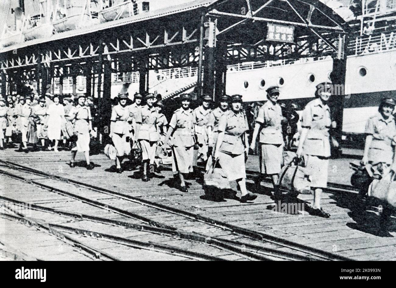 Distaccamenti medici britannici in arrivo a Hong Kong, infermieri in uniforme tropicale sbarcano al molo. Foto Stock